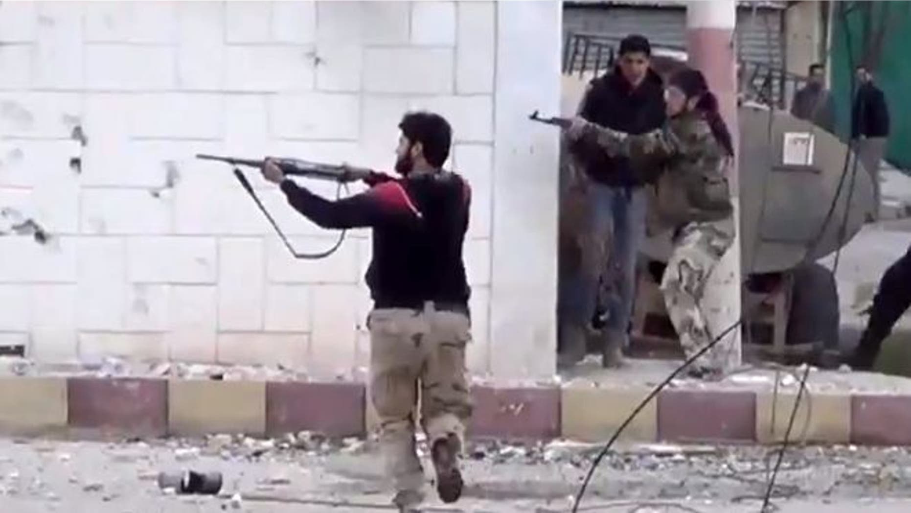 FILE: March 18, 2013: Free Syrian Army fighters fire at Syrian army soldiers during a fierce firefight in Daraa al-Balad, Syria.