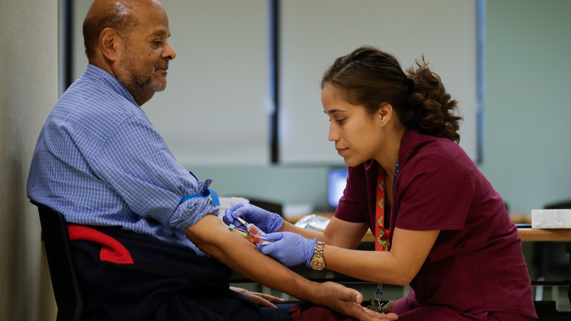 In this Thursday, Nov. 3, 2016, photo, medical assistant Jennifer Martinez draws blood from Joshua Smith that will be tested for PFOS levels in Newburgh, N.Y. State officials recently launched an ambitious effort to offer blood tests to Newburgh's about 28,000 residents after the chemical PFOS â used for years in firefighting foam at the nearby military air base â was found in the city's drinking water reservoir at levels exceeding federal guidelines. (AP Photo/Mike Groll)