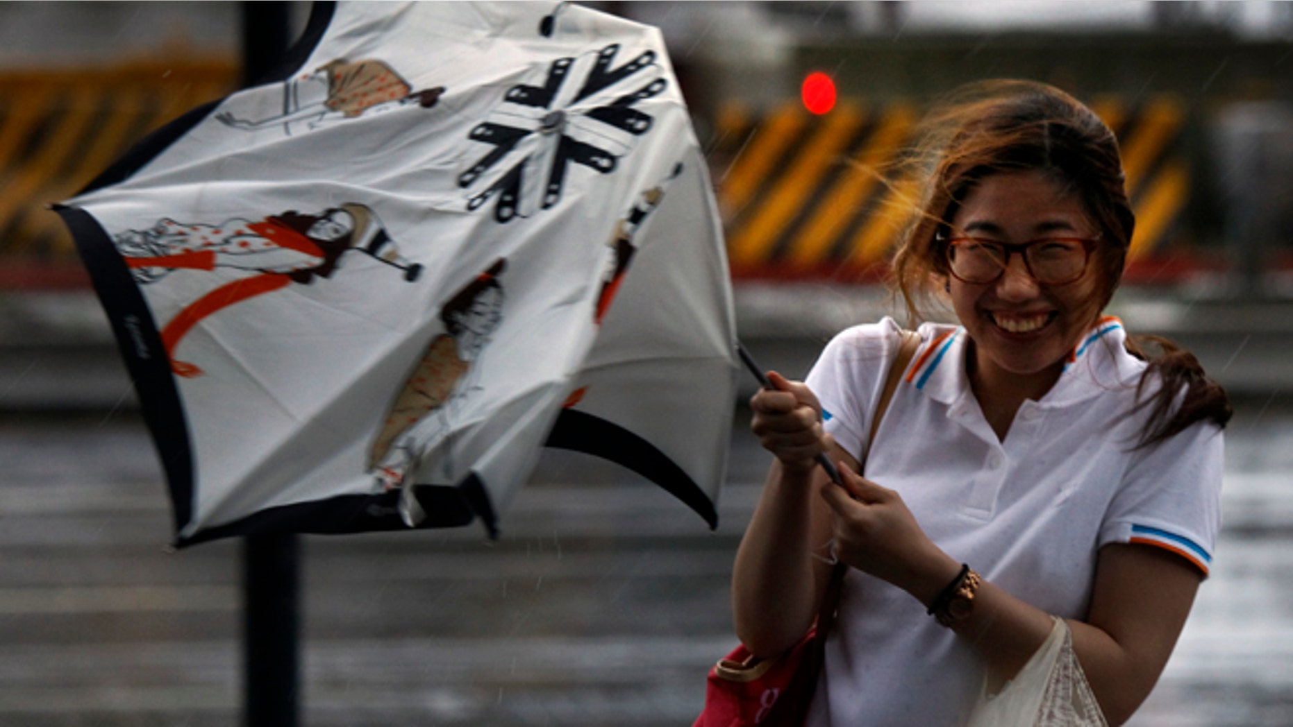 August 1, 2012: A woman reacts upon her umbrella was damaged by strong winds from an approaching typhoon in Taipei, Taiwan.