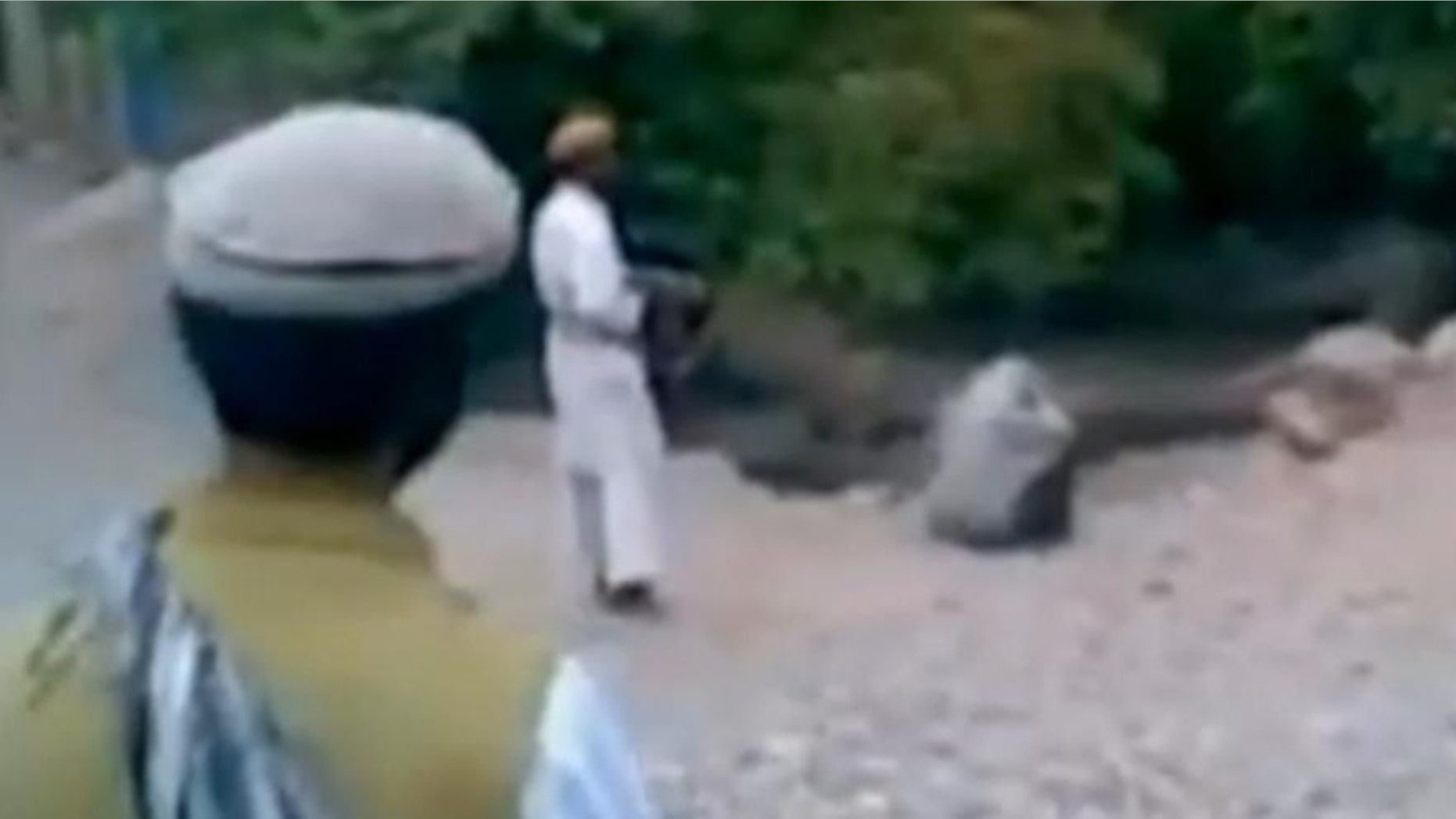 This image taken from a Reuters video allegedly shows a woman being executed by a purported member of the Taliban.