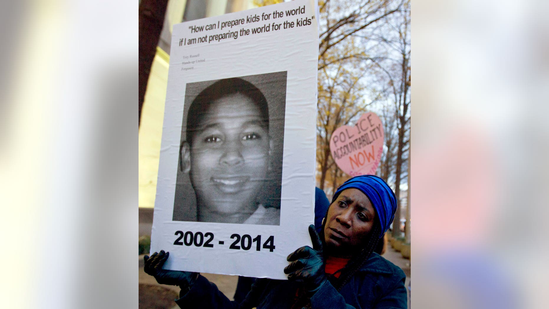 A woman holds up a picture of Tamir Rice, 12, who was fatally shot by a police officer in Cleveland, Ohio.