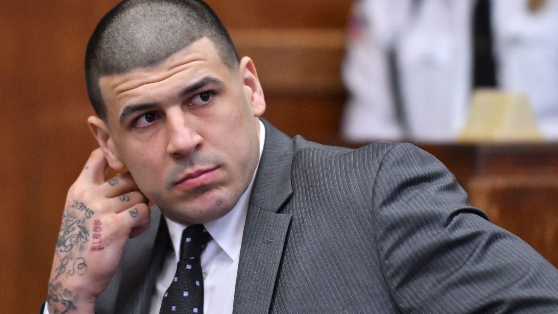 FILE- In this Dec. 27, 2016, file photo, former New England Patriots player Aaron Hernandez appears in Suffolk Superior Court for a pretrial hearing before Judge Jeffrey Locke in Boston. Hernandez, who is serving a life sentence for a 2013 murder, is scheduled to go on trial in Feb 13, 2017, for the murder of two men in a 2012 drive-by shooting. Body art has played a role in a surprising number of criminal cases nationwide, though legal experts concede that tattoos by themselves are rarely a deciding factor in convictions. (Josh Reynolds/The Boston Globe via AP, Pool, File)
