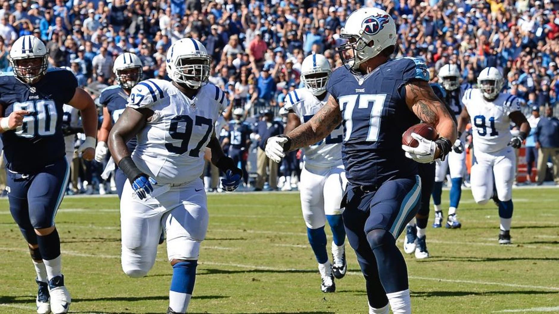 Tennessee Titans tackle Taylor Lewan (77) beats Indianapolis Colts defensive tackle Arthur Jones (97) to the end zone as Lewan scores a touchdown on a 10-yard pass play in the first half of an NFL football game Sunday, Oct. 23, 2016, in Nashville, Tenn. (AP Photo/Mark Zaleski)