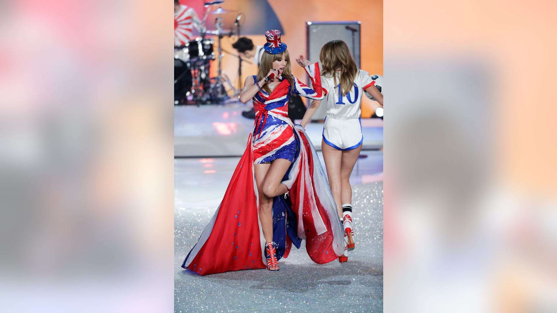 Singer Taylor Swift performs as model Cara Delevingne (R) presents a creation during the annual Victoria's Secret Fashion Show in New York, November 13, 2013. REUTERS/Lucas Jackson (UNITED STATES - Tags: ENTERTAINMENT FASHION) - RTX15CKZ