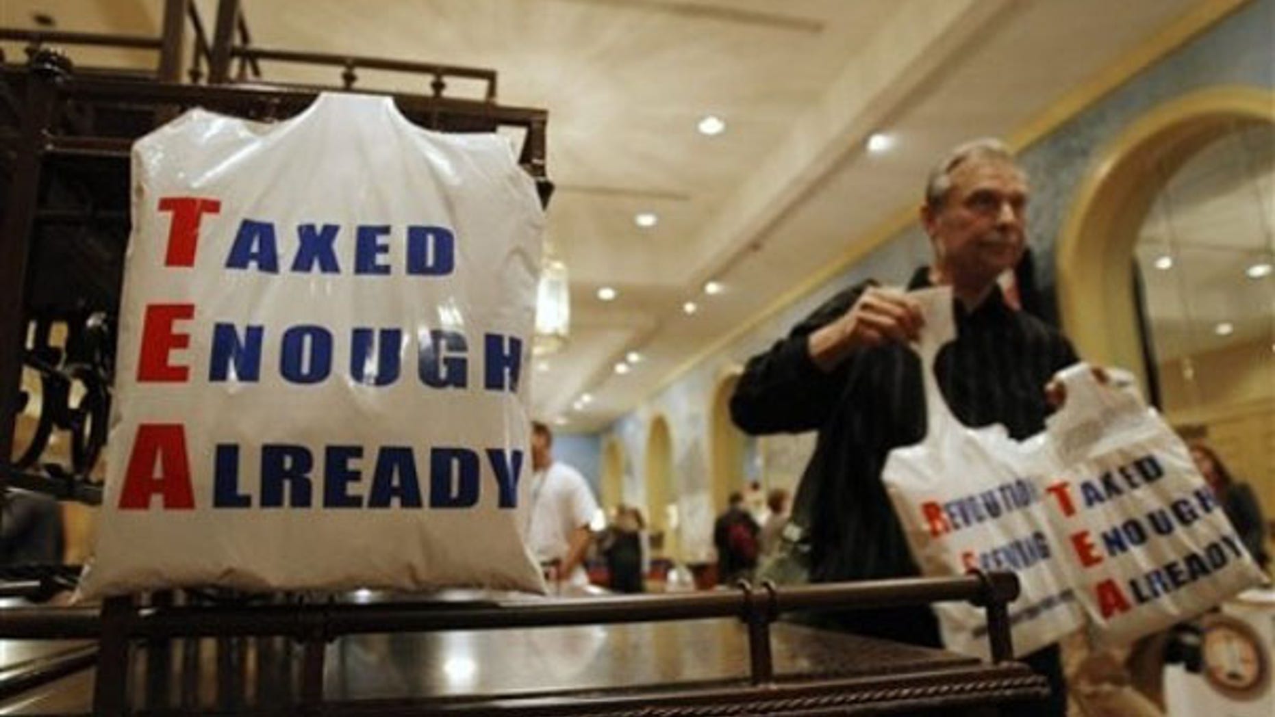 A vendor gives away plastic bags at the National Tea Party convention in Nashville Feb. 5. (AP Photo)