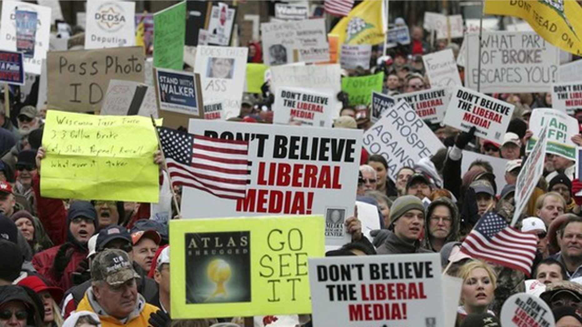 April 16, 2011: People hold signs in support of the Tea Party during a Tax Day rally in Madison, Wis.
