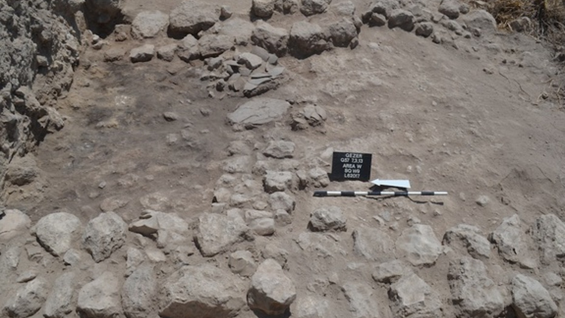Burned ruins and fired mudbrick collapse, as well as smashed pottery, reveal the late Bronze Age destruction at the city. On the left is the room where several pottery vessels, a scarab of Amenhotep III, a cache of cylinder seals, as well as s