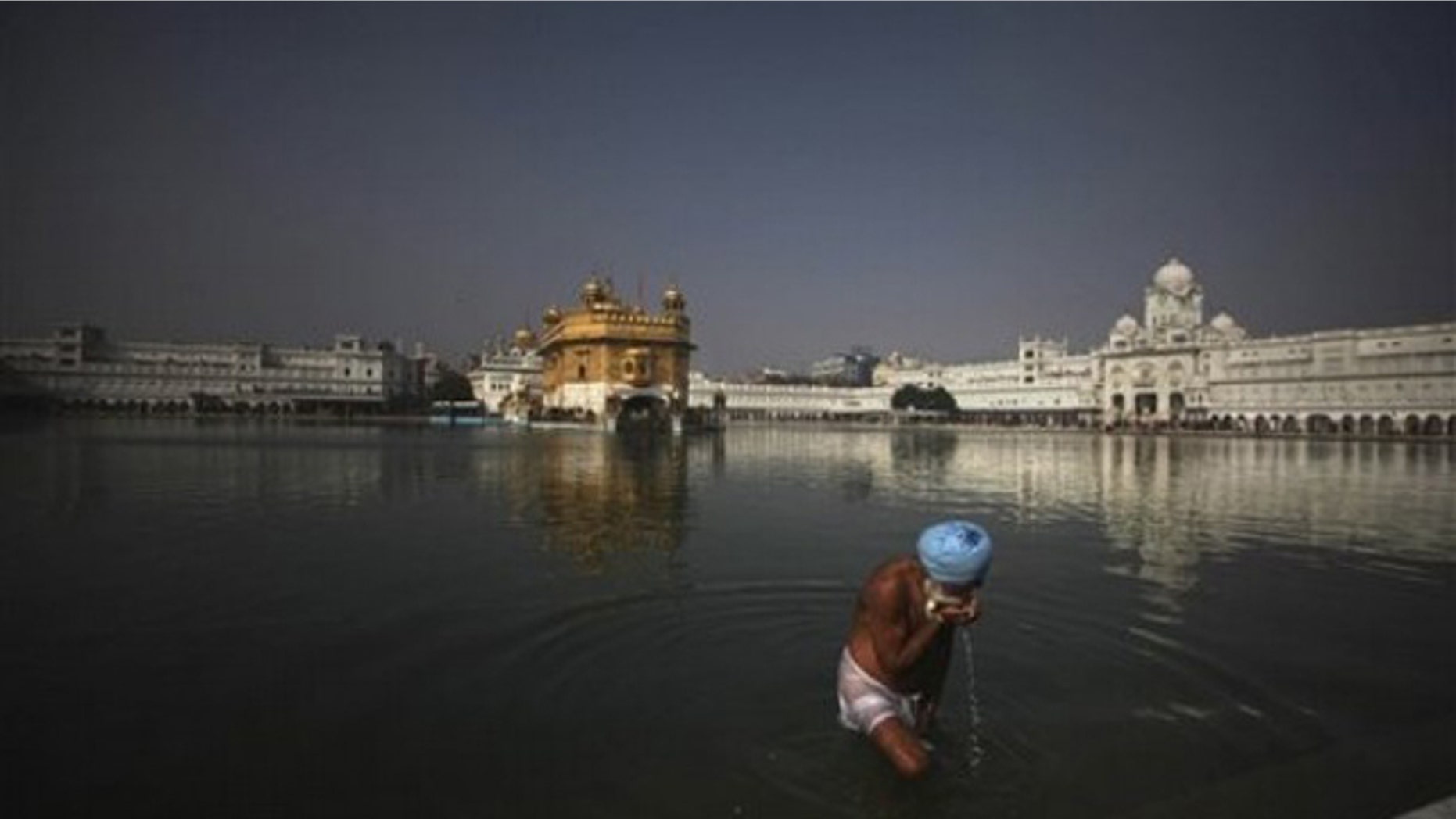 A Sikh devotee drinks water from the holy pond at the Golden Temple in Amritsar, India, on Jan. 4. (AP Photo)