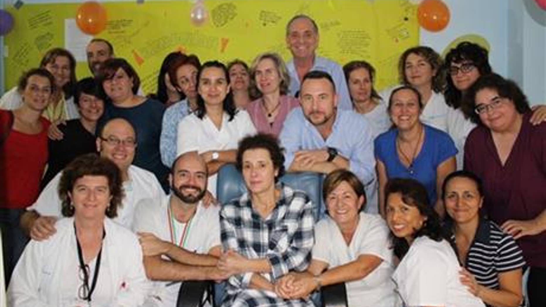 This Nov. 1, 2014 photo provided by the Madrid’s Carlos III hospital shows Teresa Romero, center, posing for a photo with medical workers and friends after leaving the isolation unit in the Carlos III hospital in Madrid, Spain.