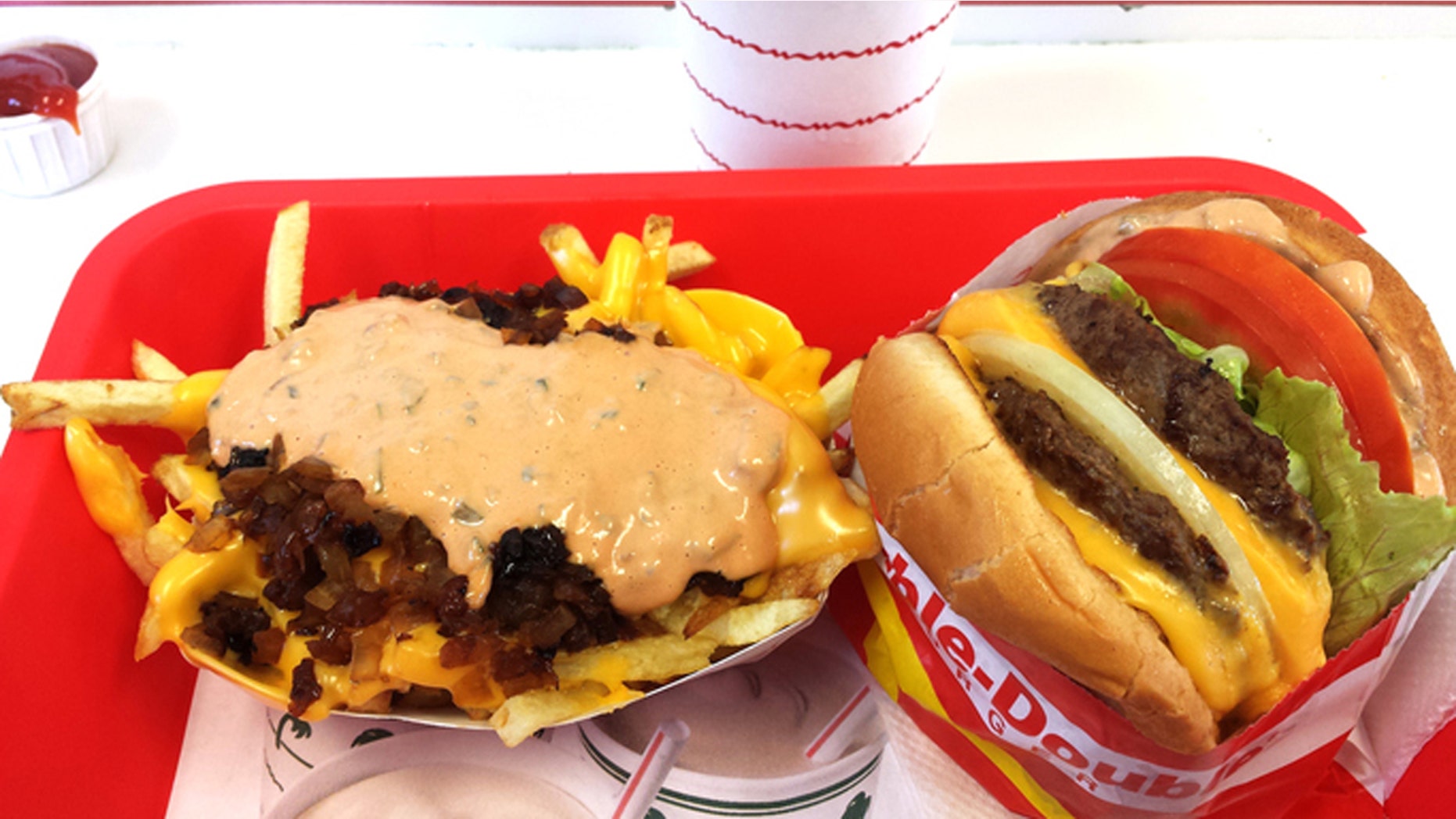 Los Angeles, California, USA - August 20, 2015: In-N-Out Burgers, Inc. is a regional chain of fast food restaurants that started in California. Two of their most popular menu items are the "Double-Double" hamburger - two hamburger patties with two slices of cheese, and the "Animal Style" french fries - two slices of melted cheese, spread, and grilled onions on top.