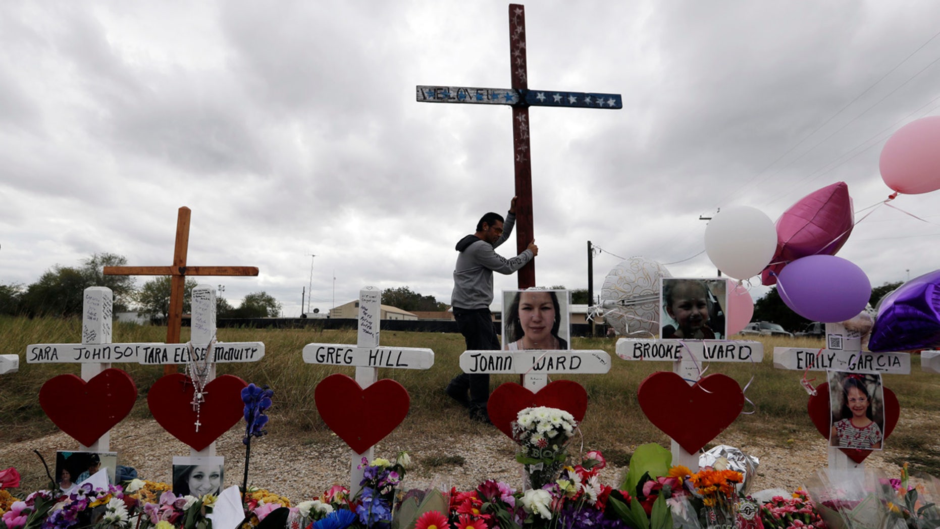 Miguel Zamora strands a cross for the victims of the Sutherland Springs First Baptist Church shooting at a makeshift memorial, Nov. 11, 2017.