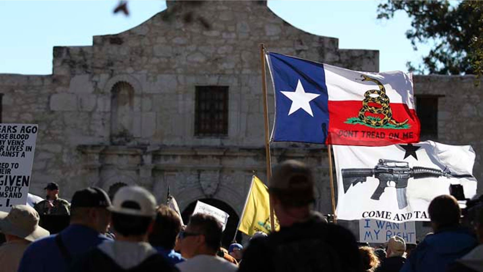 Oct. 19, 2013: In this file photo, flags fly at the "Come And Take It San Antonio" rally. Long depicted as the rootin'-tootin' capital of American gun culture, Texas is one of the few states with an outright ban on the open carry of handguns. That could change next year, with an expected push for expanding gun rights from the Republican-dominated Legislature.