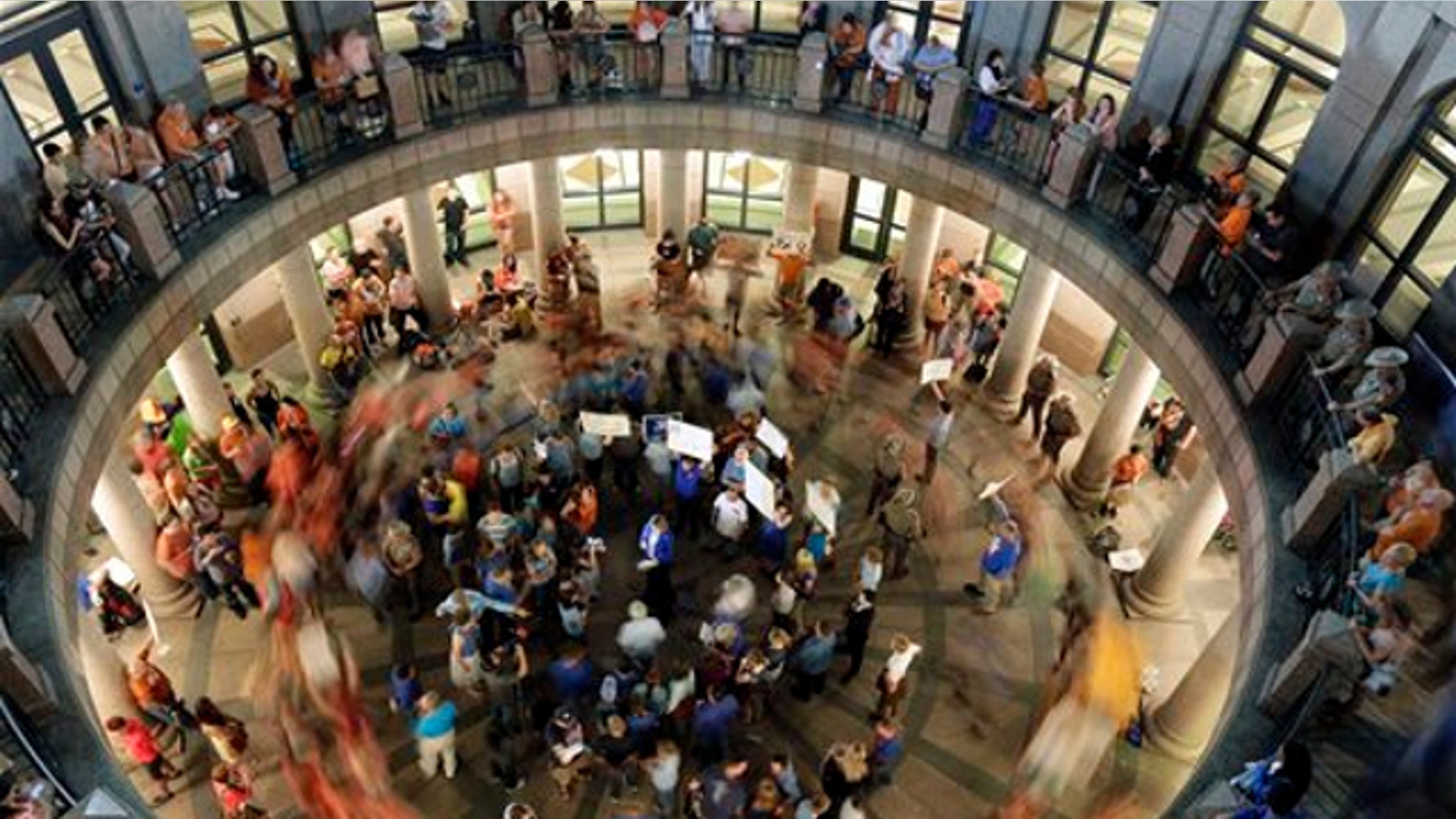 July 2, 2013: Opponents of an abortion bill walk in circles around supporters of the bill as a committee holds hearings on the bill near by at the Texas state capitol in Austin, Texas.