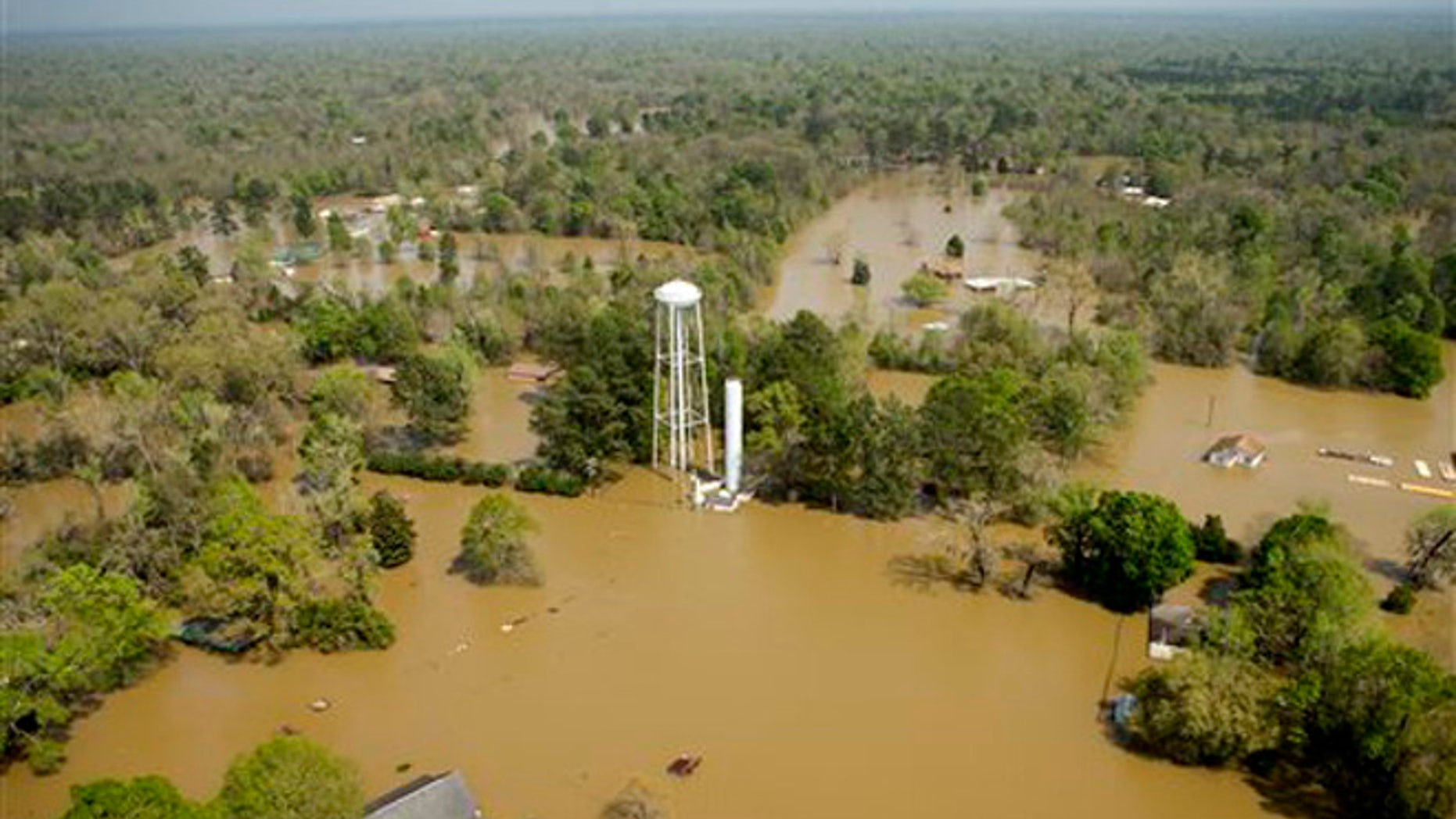In this aerial photo, homes are surrounded by floodwaters from the nearby Sabine River following recent heavy rains, Tuesday, March 15, 2016, in Deweyville, Texas. (Brett Coomer/Houston Chronicle via AP) MANDATORY CREDIT