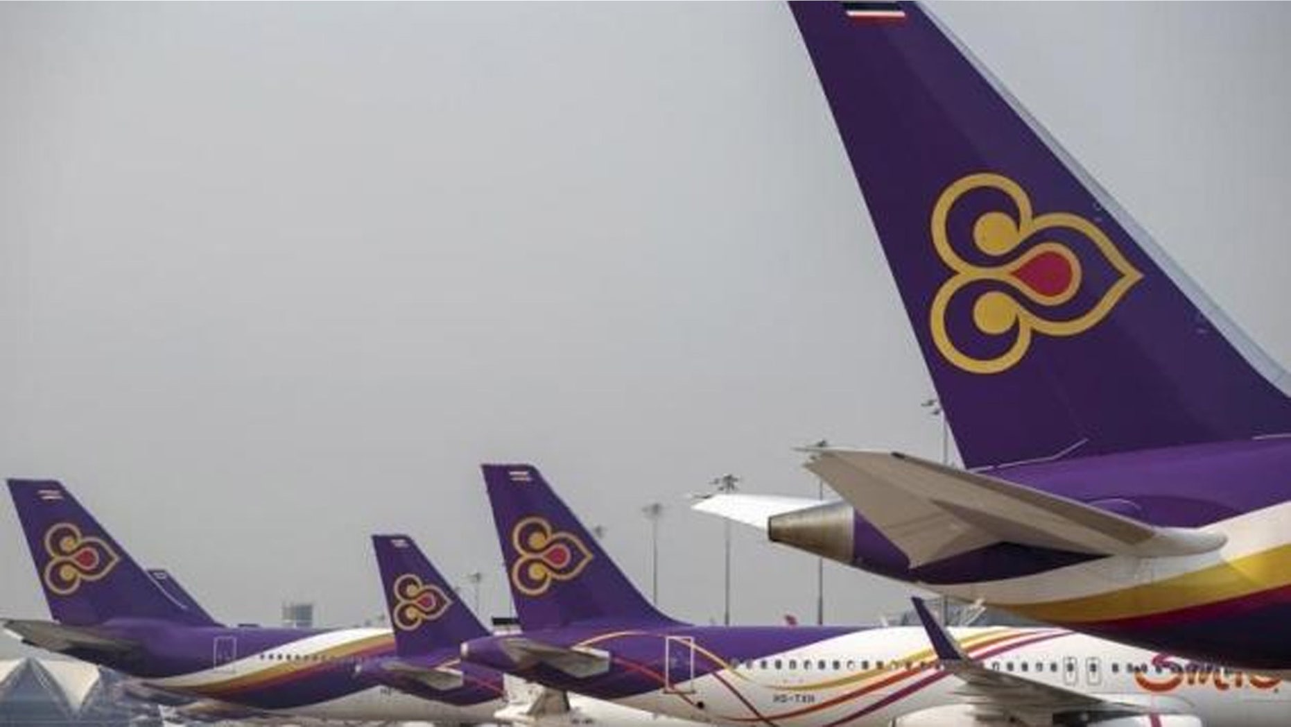 The photo shows a flight attendant assisting a passenger on a Thai Airways flight from Bangkok to Kuala Lumpur last week.