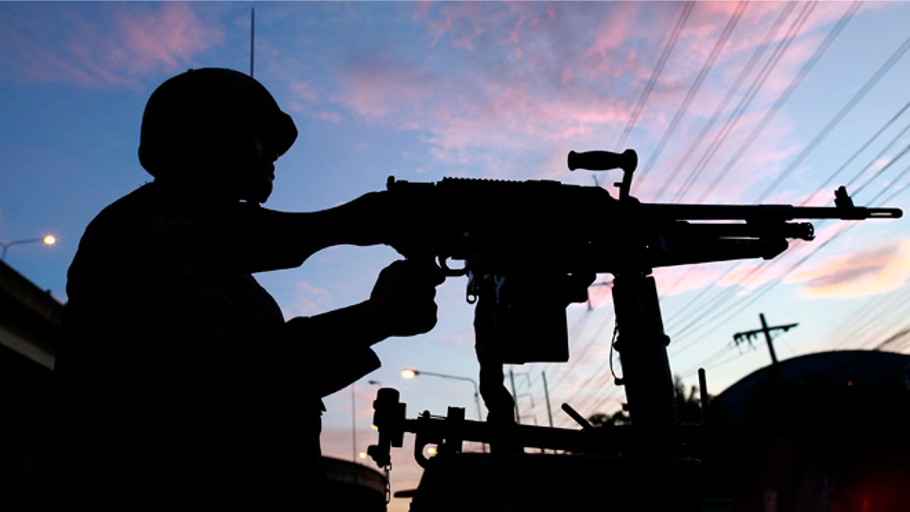 May 20, 2014: A Thai soldier mans his machine gun atop a military vehicle outside the Centre for the Administration of Peace and Order (CAPO) after soldiers were sent in the center in Bangkok, Thailand.