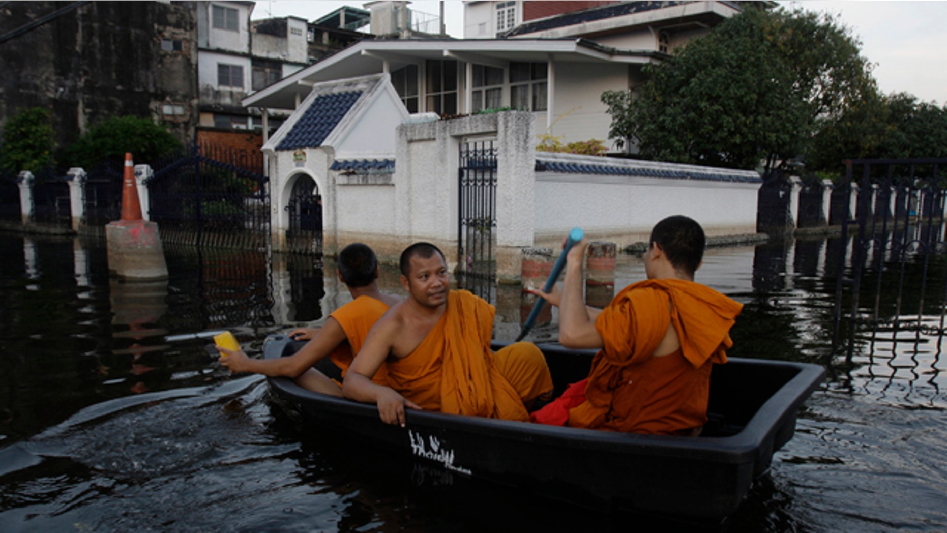 Nov. 6, 2011: Thai Buddhist monks navigate a small boat along flooded streets in Bangkok, Thailand.