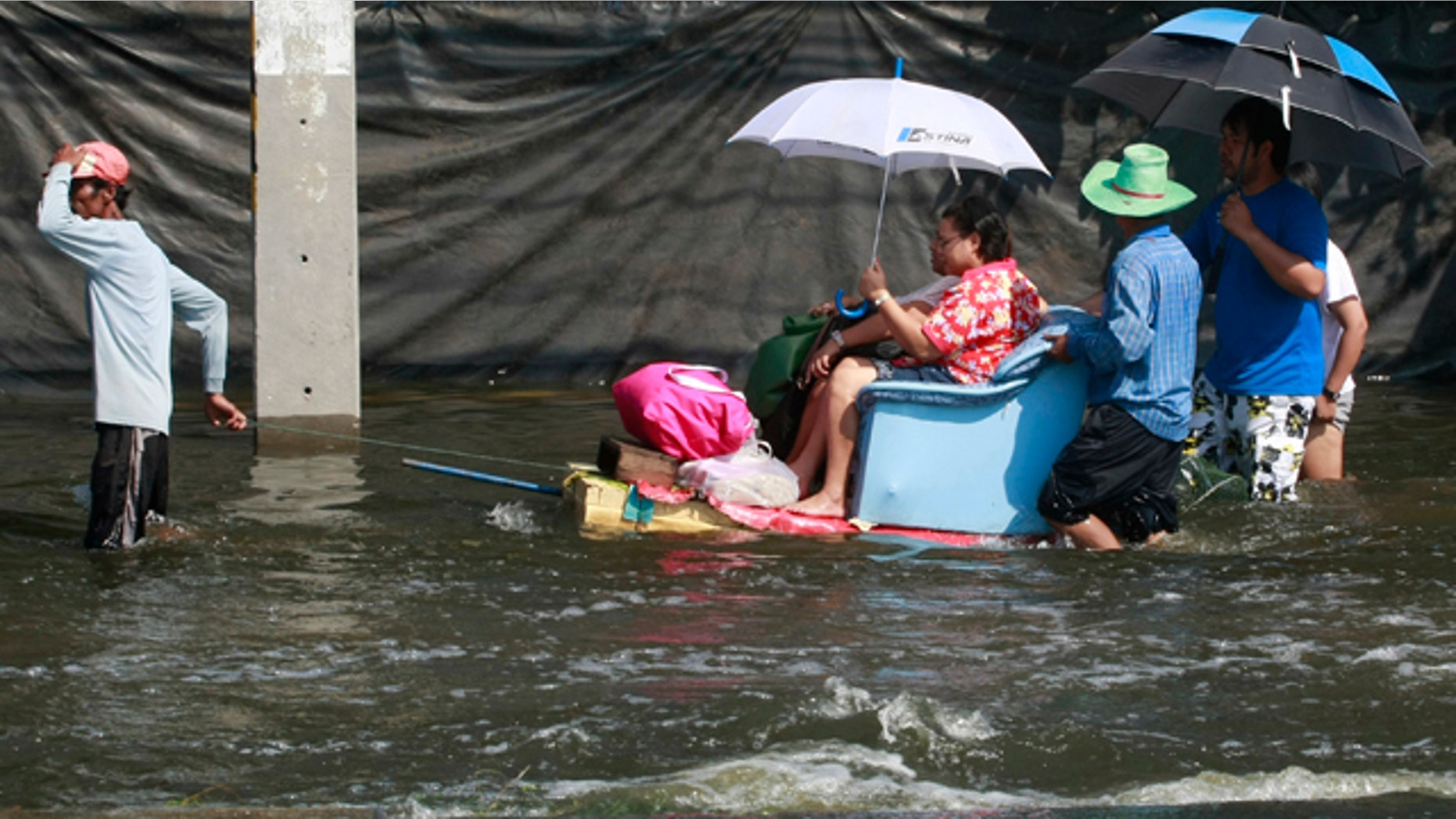 Oct. 24, 2011: A man pulls his decorated boat while making a service to his passenger on a flooded road in Bangkok, Thailand.