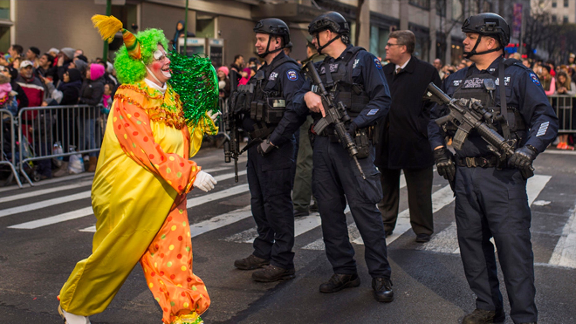 Nov. 26, 2015: A clown marches by heavily armed police stand guard during the Macy's Thanksgiving Day Parade in New York.