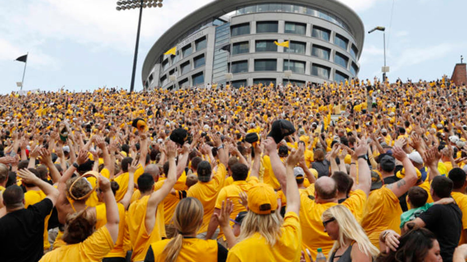 Iowa fans wave to children in the University of Iowa Stead Family Children's Hospital at the end of the first quarter of an NCAA college football game against North Texas, Saturday, Sept. 16, 2017,
