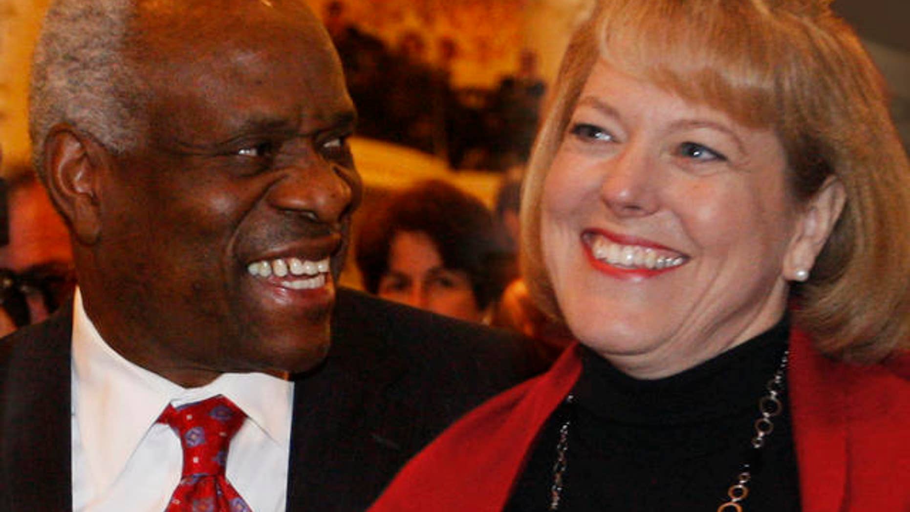 FILE: In this Nov. 15, 2007, photo, Supreme Court Justice Clarence Thomas, left, sits with his wife Virginia Thomas, as he is introduced at the Federalist Society in Washington.