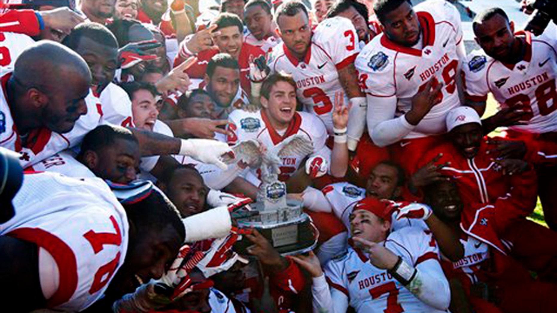 Houston players celebrate with the championship trophy after defeating Penn State in the TicketCity Bowl NCAA college football game, Monday, Jan. 2, 2012, at the Cotton Bowl in Dallas.