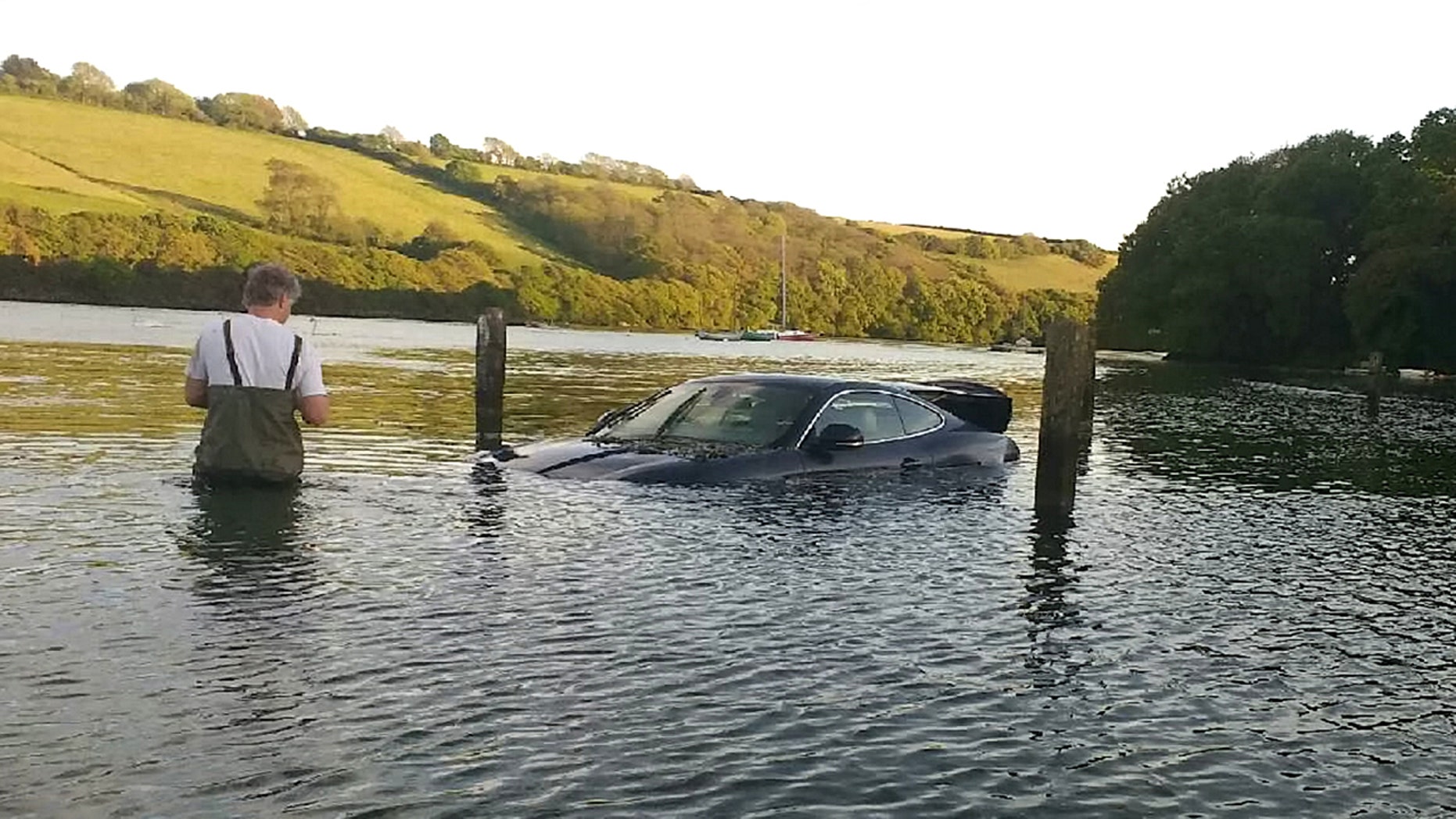 This picture shows the moment an expensive Jaguar was consumed by water - after the owner left the car parked on a tidal road. See SWNS story SWJAG; The black Jaguar XK, which cost around £60,000 when new, can be seen with the boot open and water nearly to the top of the windows. Chris and Gill Freeborn were passing in their boat when they spotted the unfortunate situation, and quickly took some snaps. Gill said the sight made her "howl with laughter", and Chris said the Jaguar was "clearly not a happy pussy cat". The car, worth around £10,000 on the current market, has now been removed from Aveton Gifford tidal road in Kingsbridge, Devon.