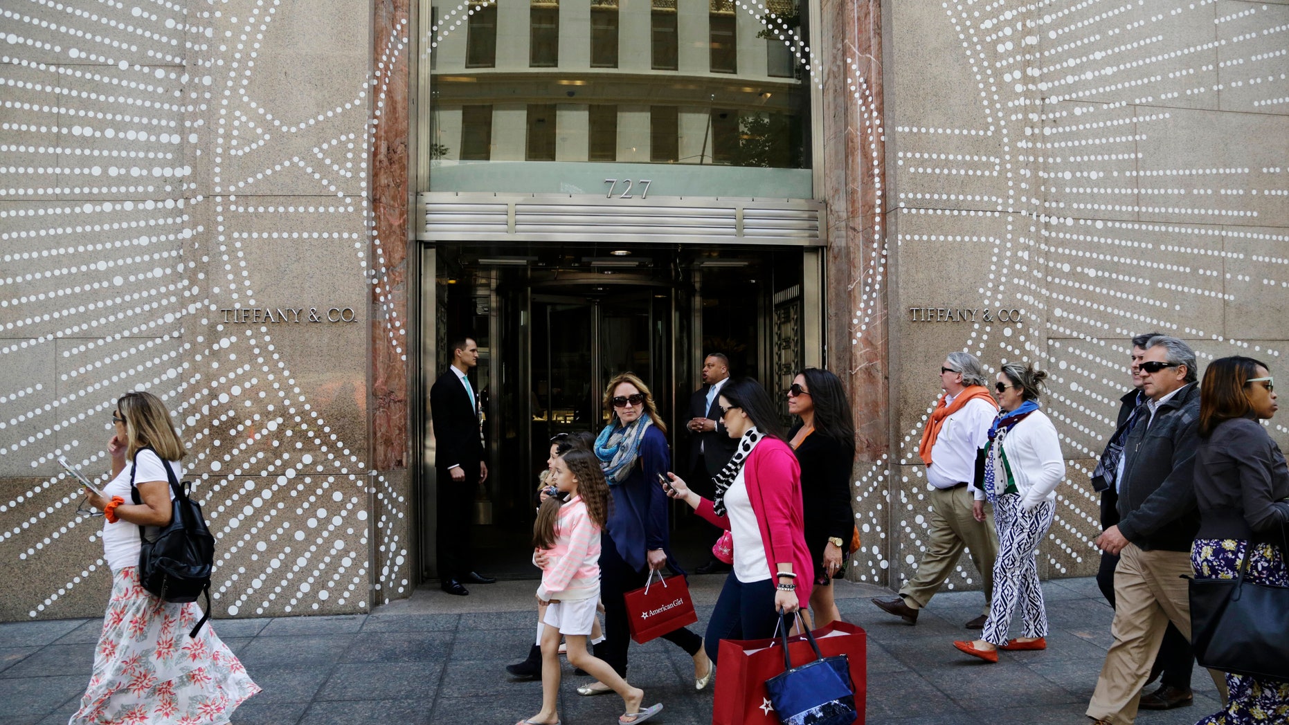 Shoppers walk by Tiffany & Company's Fifth Avenue store in New York.