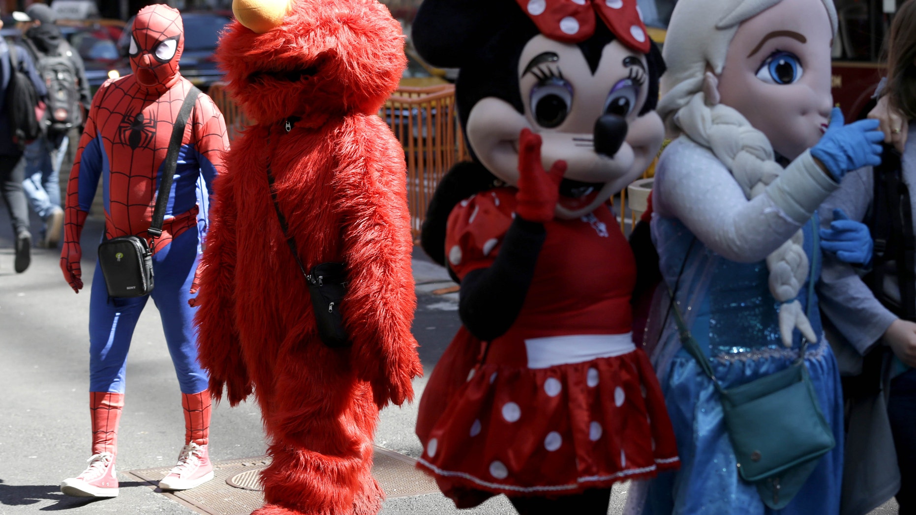 Costumed characters work for tips in Times Square.