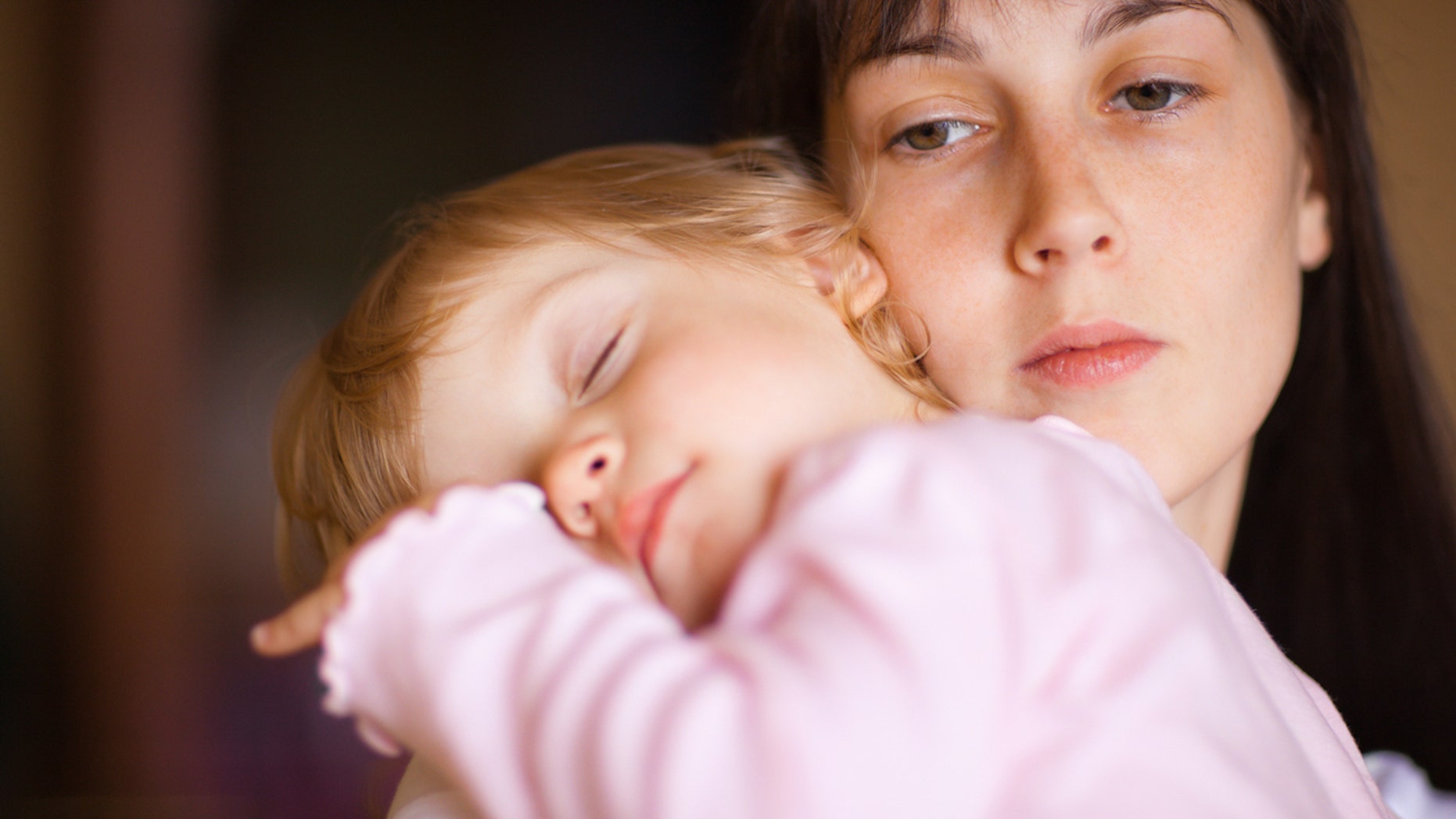 Sleepy little child with mom - shallow DOF, focus on woman's eyes