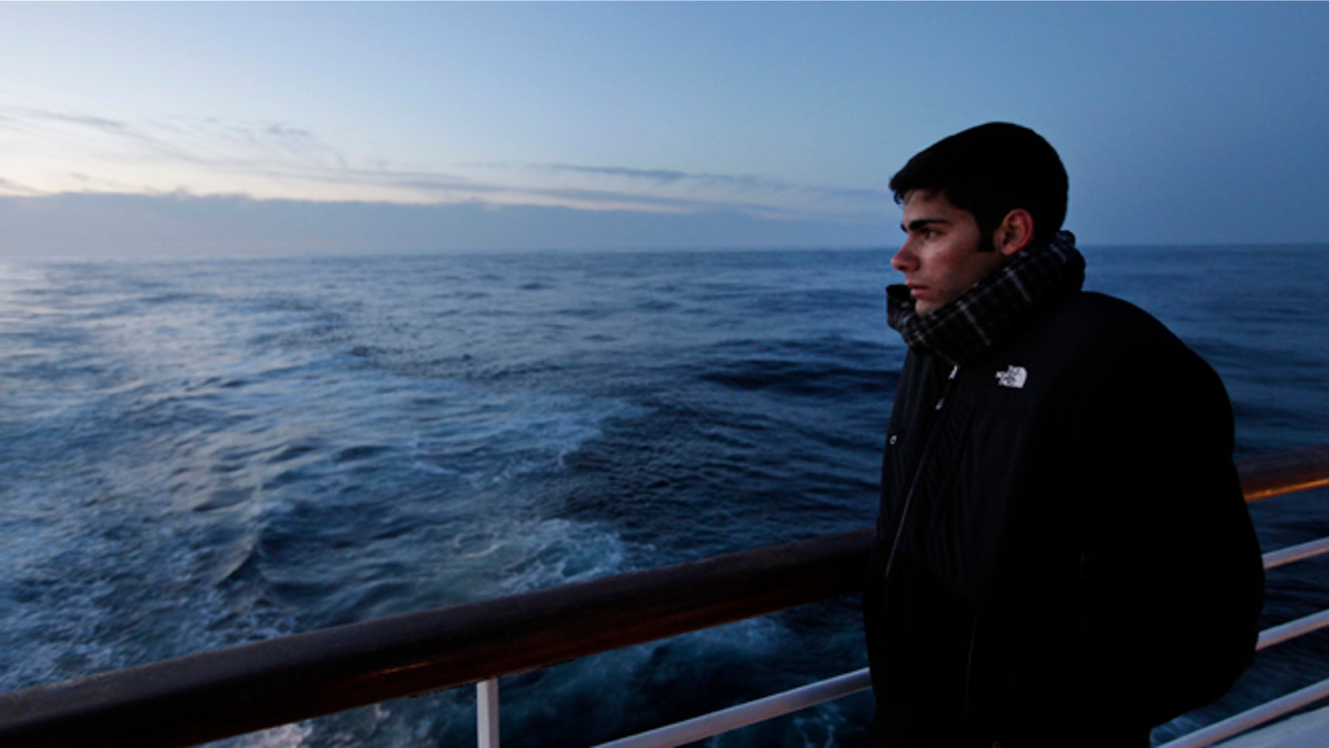 A passenger of MS Balmoral Titanic memorial cruise ship, gazes out to the Atlantic Ocean, following a memorial service, marking the 100-year anniversary of the Titanic disaster, in the early hours of Sunday, April 15, 2012.