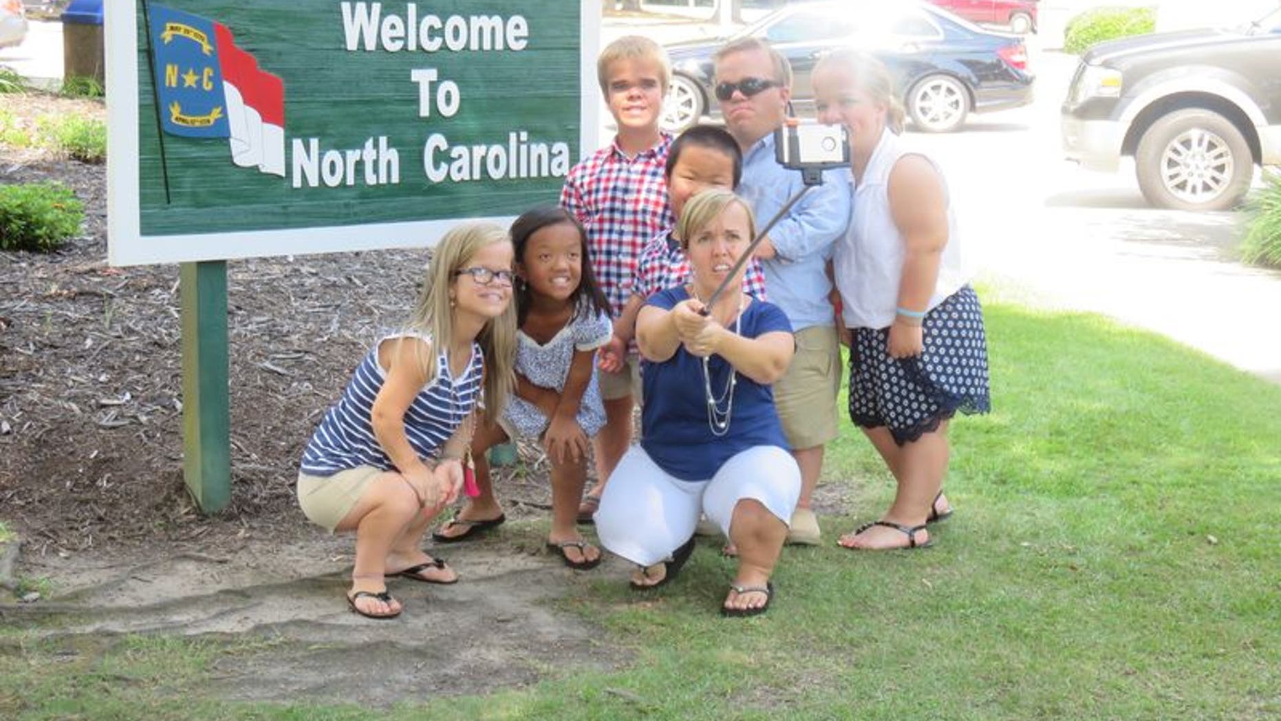 The Johnston family taking a selfie at the North Carolina state border sign.