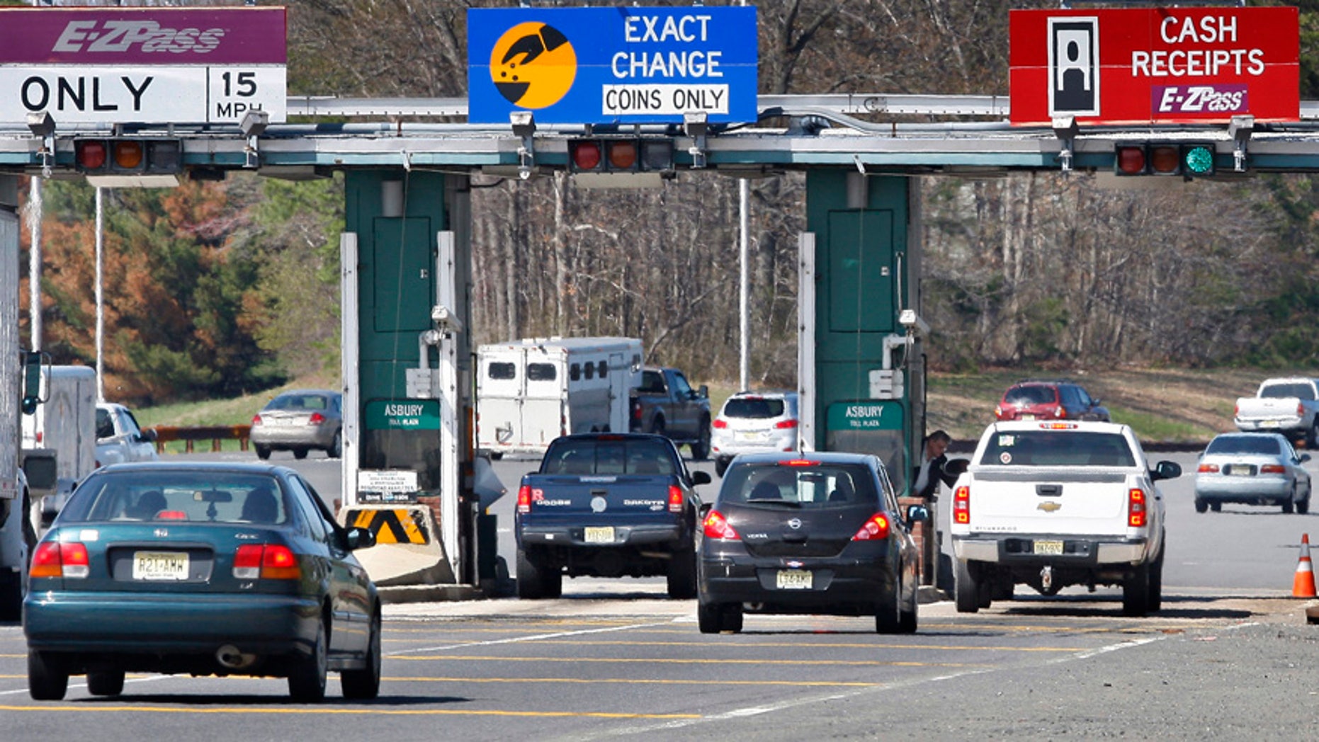 FILE- In this April 21, 2011, file photo, cars pass through the toll booths at the Garden State Parkway's Asbury toll plaza near Tinton Falls, N.J. Although the average drive grudgingly pays tolls for highways, bridges and tunnels, some go to great lengths to beat those tolls. Many of those drivers have racked up thousands of dollars in unpaid tolls and related fees that can lead to theft and other criminal charges. (AP Photo/Mel Evans, File)