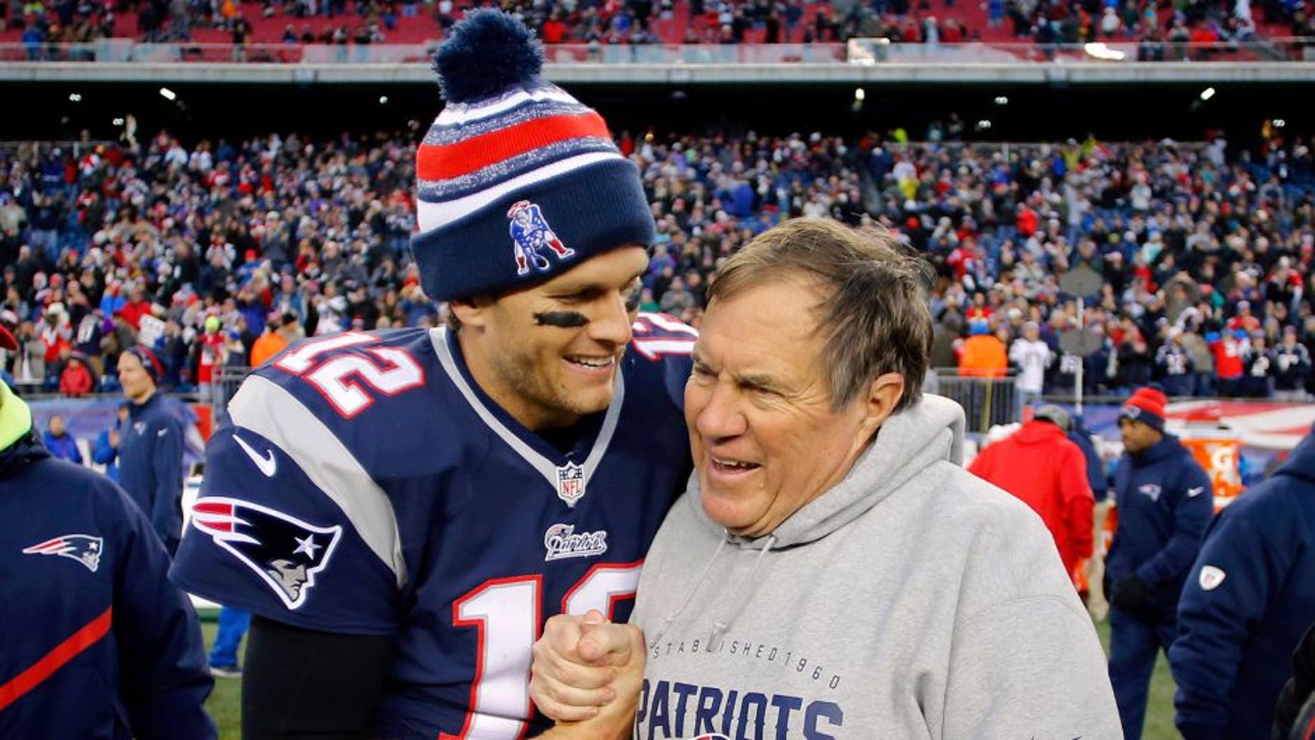 Dec 14, 2014; Foxborough, MA, USA; New England Patriots quarterback Tom Brady (12) celebrates with head coach Bill Belichick (R) after clinching the AFC East title with a 41-13 win over the Miami Dolphins at Gillette Stadium. Mandatory Credit: Winslow Townson-USA TODAY Sports