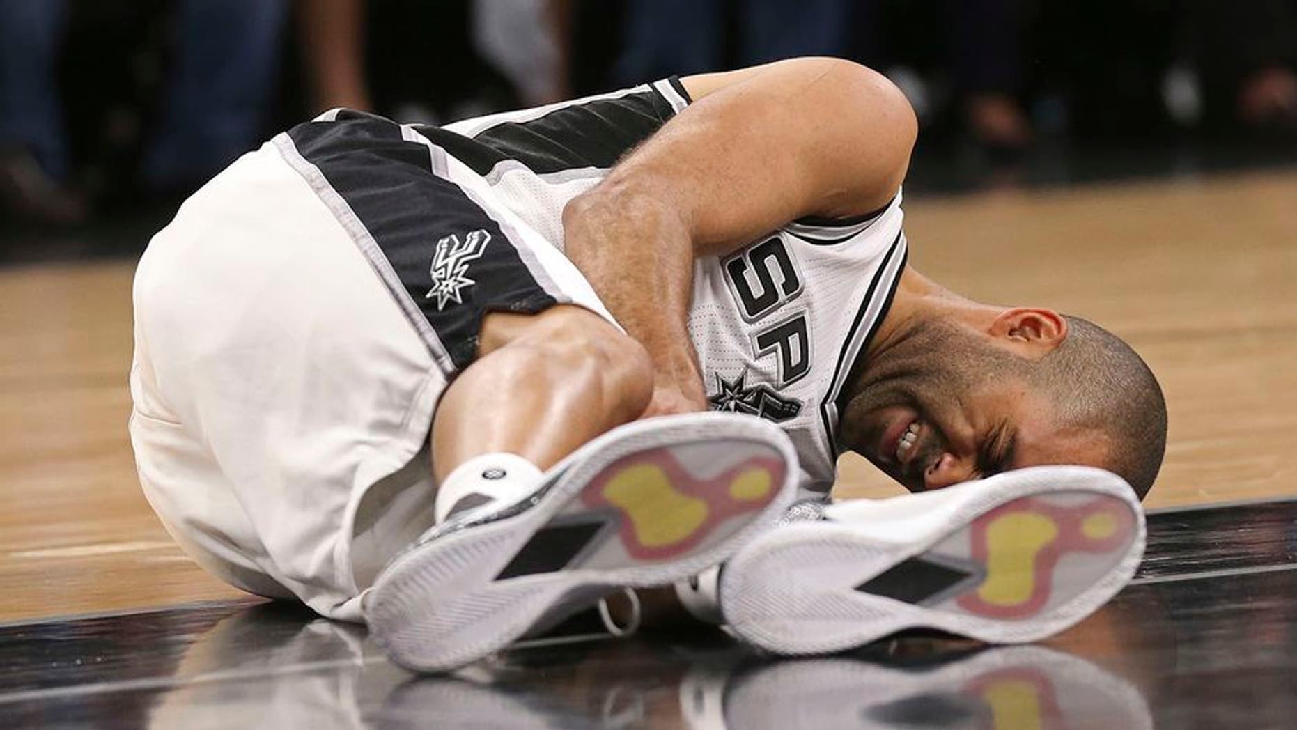 In this Wednesday, May 3, 2017 photo, San Antonio Spurs' Tony Parker holds his left leg after getting injured in the second half of Game 2 of the Western Conference semifinals at the AT&T Center against the Houston Rockets in San Antonio. The Spurs announced on Thursday, May 4, 2017, that Parker has a ruptured quadriceps tendon in his left leg. (Jerry Lara/The San Antonio Express-News via AP)