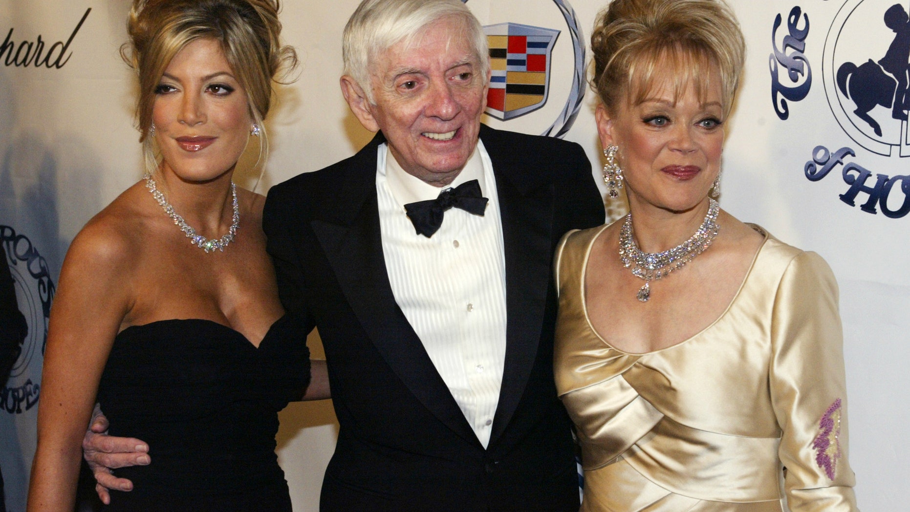 October 15, 2002. Actress Tori Spelling (L) is pictured with her mother Candy Spelling (R) and her late father, television producer Aaron Spelling, at the Carousel of Hope charity ball in Beverly Hills, California.