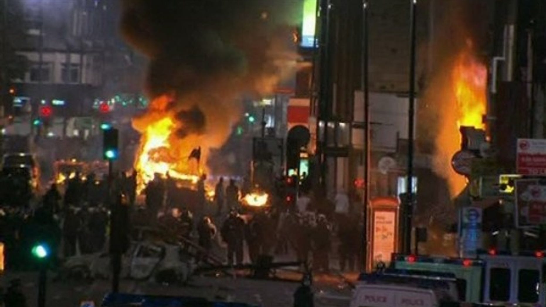 Aug. 6: In this image from video, a bus and shop burn in Tottenham, north London after two police cars were attacked by members of a community where a young man was shot dead by police on Thursday.