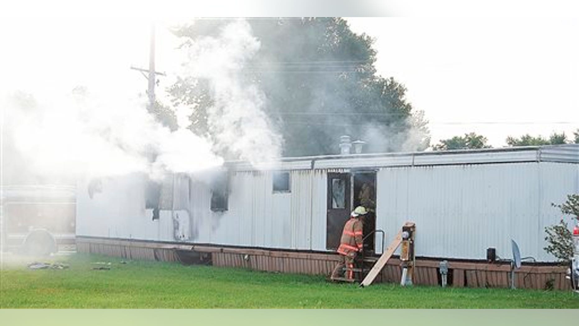Firefighters extinguish a mobile home fire Sunday, Sept. 15, 2013, that killed a man and five children in Tiffin, Ohio.
