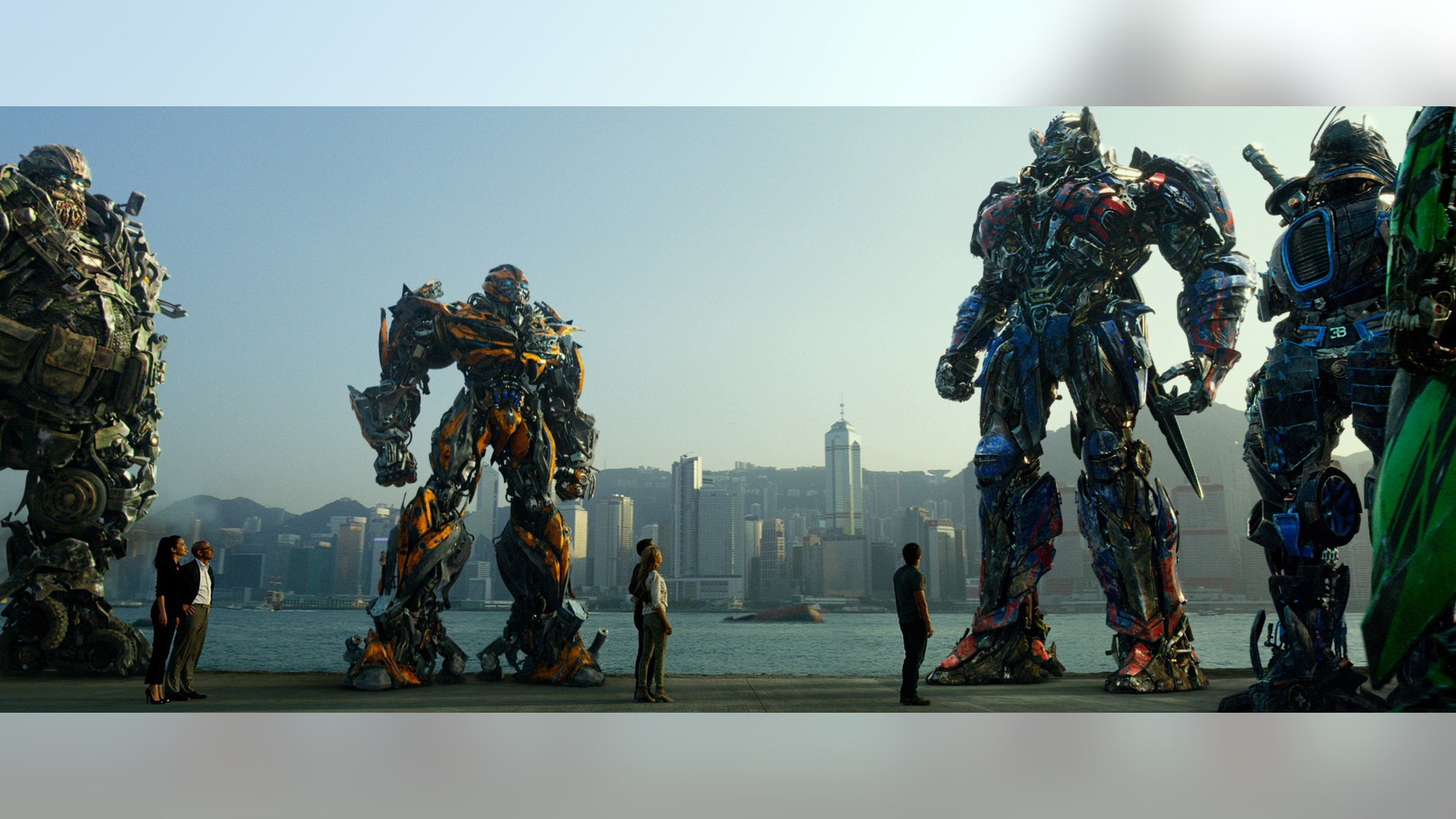 Hound, Bingbing Li as Su Yueming, Stanley Tucci as Joshua Joyce, Bumblebee, Jack Reynor as Shane Dyson, Nicola Peltz as Tessa Yeager, Mark Wahlberg as Cade Yeager, Optimus Prime, Drift, and Crosshairs, in a scene from the film, "Transformers: Age of Extinction."