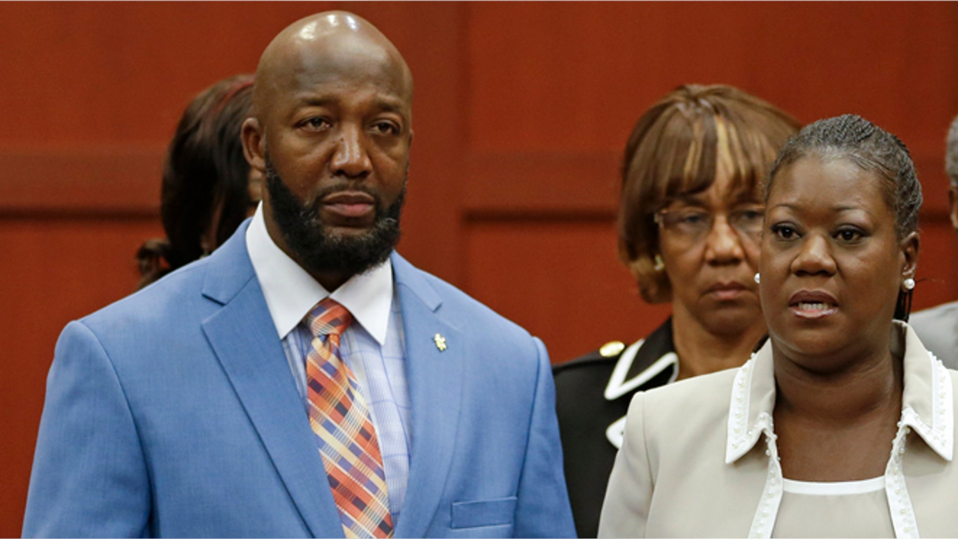June 24, 2013: Tracy Martin, left, and Sybrina Fulton, center, parents of slain teenager Trayvon Martin, speak in a news conference prior to opening arguments in the trial of George Zimmerman at the Seminole County Courthouse, in Sanford, Fla. (AP/John Raoux, File)