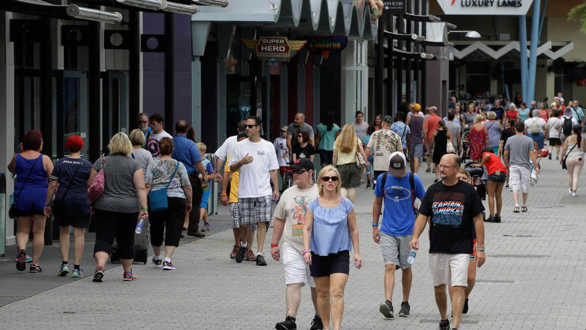 In this Tuesday, Sept. 13, 2016 photo, tourists stroll by the shops and restaurants at the Disney Spring complex in Lake Buena Vista, Fla. Hotel occupancy rates in the Orlando area are down about 2.5 percent for the year through July