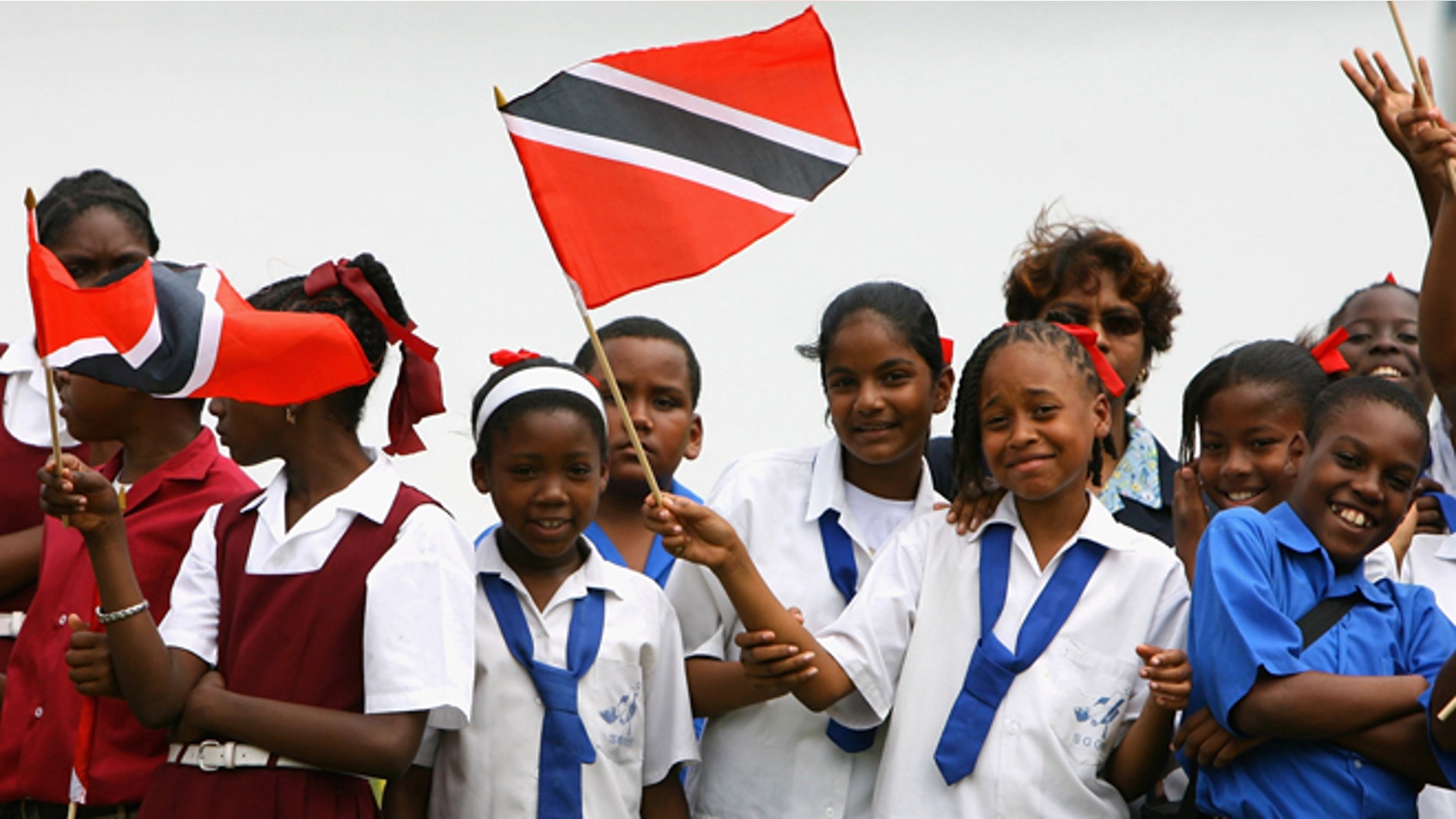 PORT OF SPAIN, TRINIDAD AND TOBAGO - MARCH 05: Children wave flags at Queen's Cricket ground on the second day of a three day tour of Trinidad and Tobago on March 5, 2008 near Port of Spain, Trinidad. The Royal Couple have arrived in Trinidad on the first leg of a ten day tour of the Caribbean. Sir Donald Gosling's Yacht Leander will transport the couple from Island to Island, then to their final destination, Jamaica. (Photo by Chris Jackson/Getty Images)