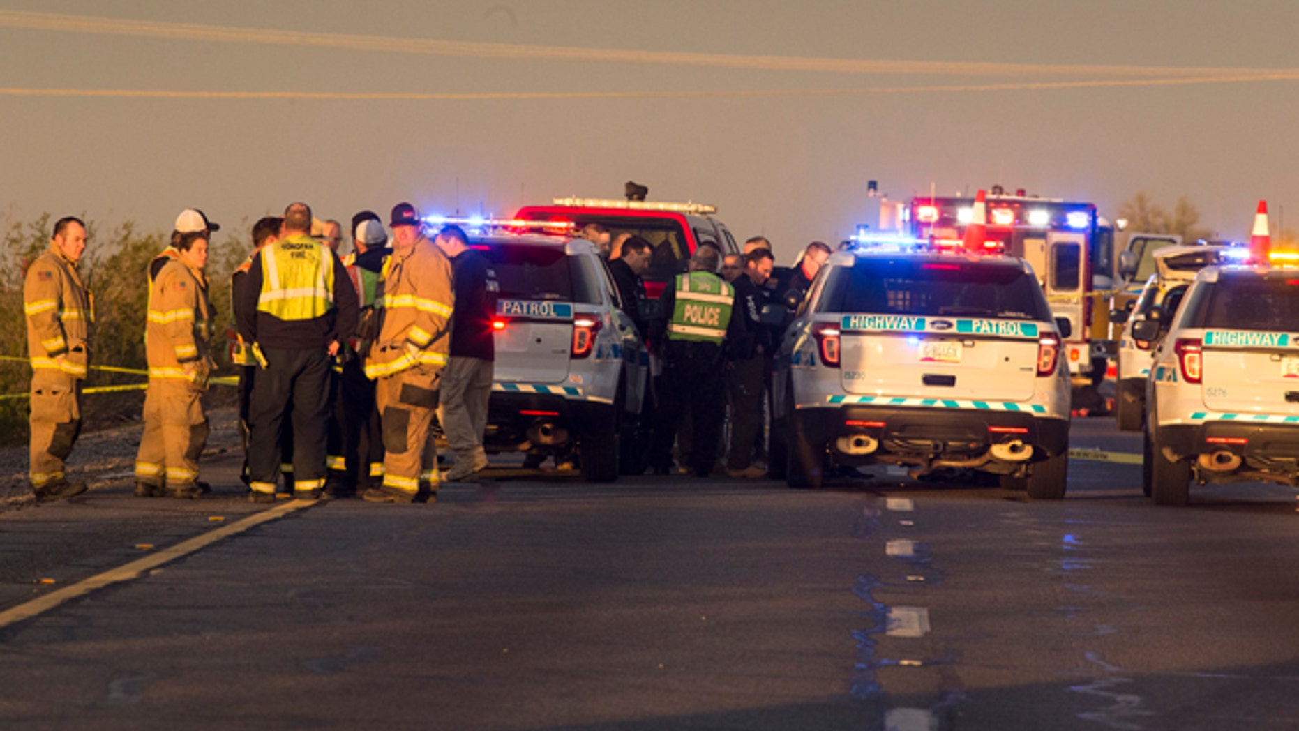 Emergency personnel gather at the scene where an Arizona Department of Public Safety trooper was shot, Thursday, Jan. 12, 2017, at the scene of a rollover accident on Interstate 10 near Tonopah, Ariz.