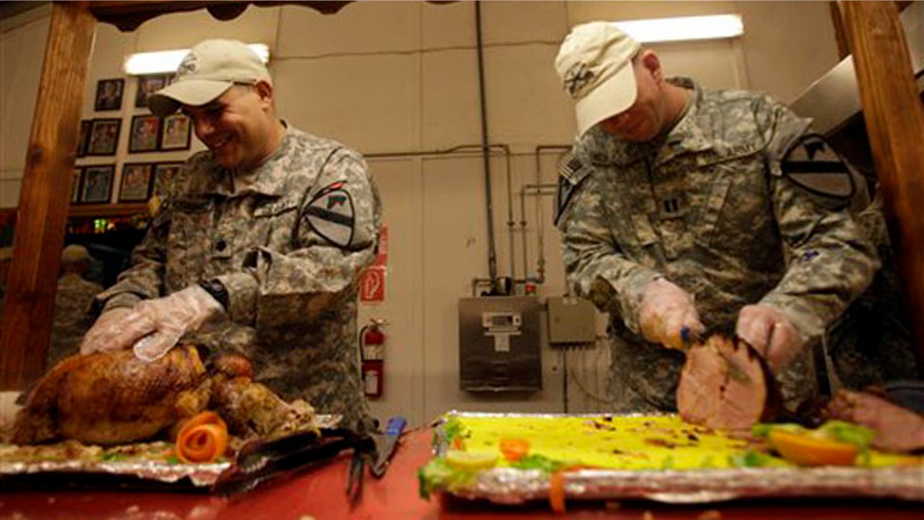 U.S. soldiers serve food for the last Thanksgiving meal at Contingency Operating Site Echo, in Diwaniyah, 120 kilometers south of Baghdad, Iraq, Thursday, Nov. 24, 2011.