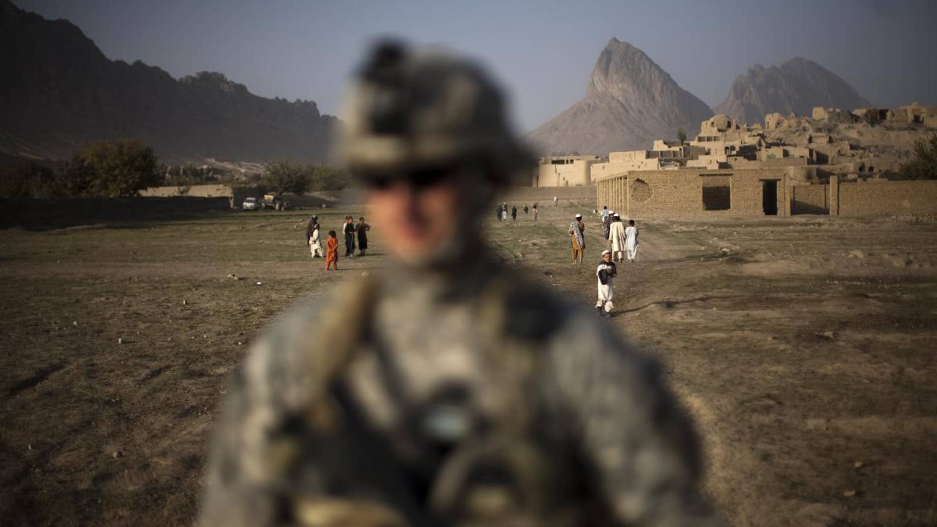 A US soldier from L Troop, 4/2SCR, walks during a foot patrol on the outskirts of Kandahar City, Afghanistan, Monday, Oct. 25, 2010. (AP Photo/Rodrigo Abd)