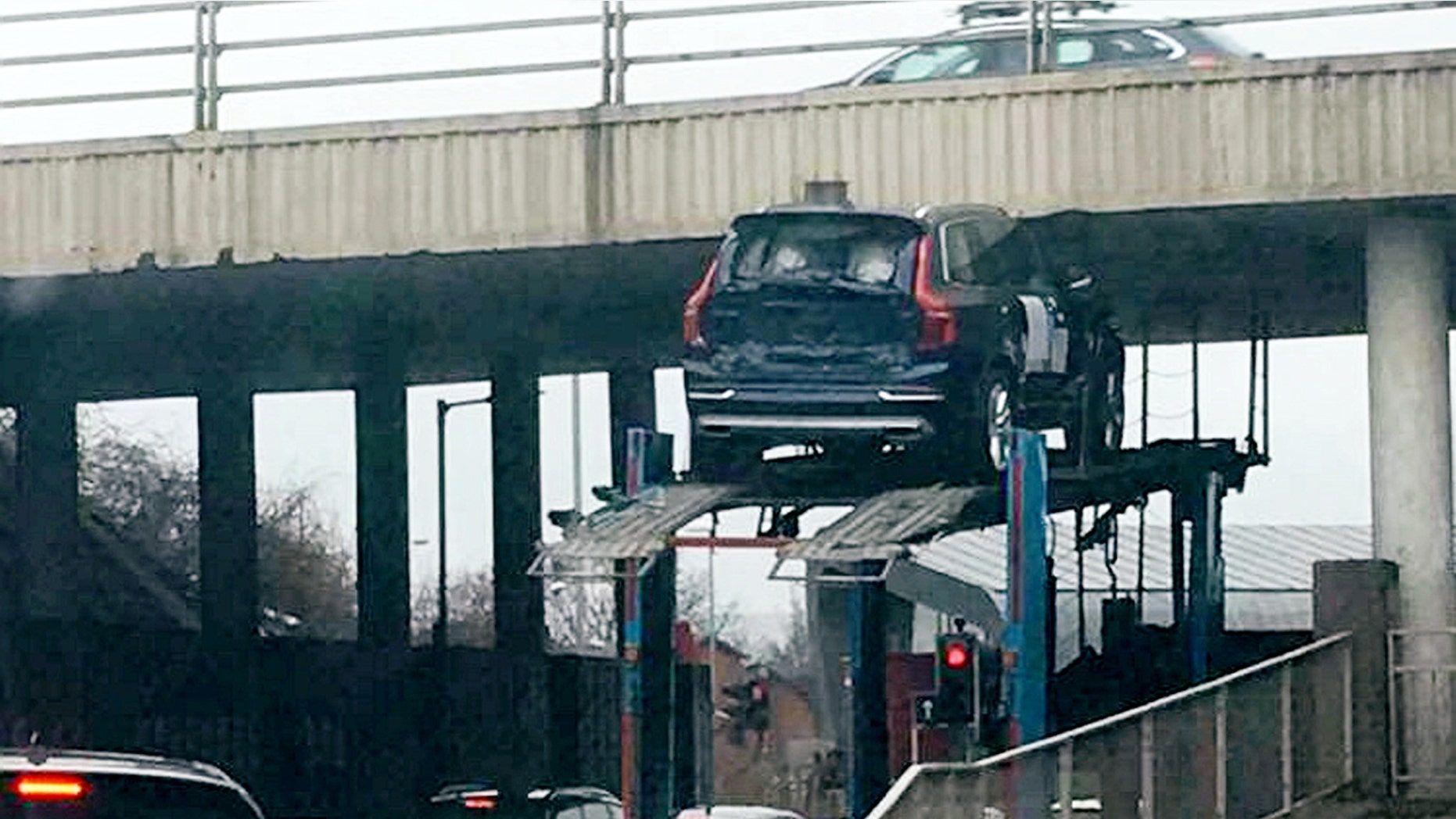This picture shows the moment a car got stuck under a bridge while on top of a transporter. See CENTRE PRESS story CPCAR. Kirsty Adams was driving from her granddadâs funeral at around 3pm on Thursday until she witnessed "a Volvo" trapped underneath the bridge. According to the 33-year-old, another car fell to the ground as the transporter attempted to drive under the low bridge. The incident which happened near a roundabout at the Hillington Industrial Estate in Glasgow left the mother-of-one and her partner stunned.