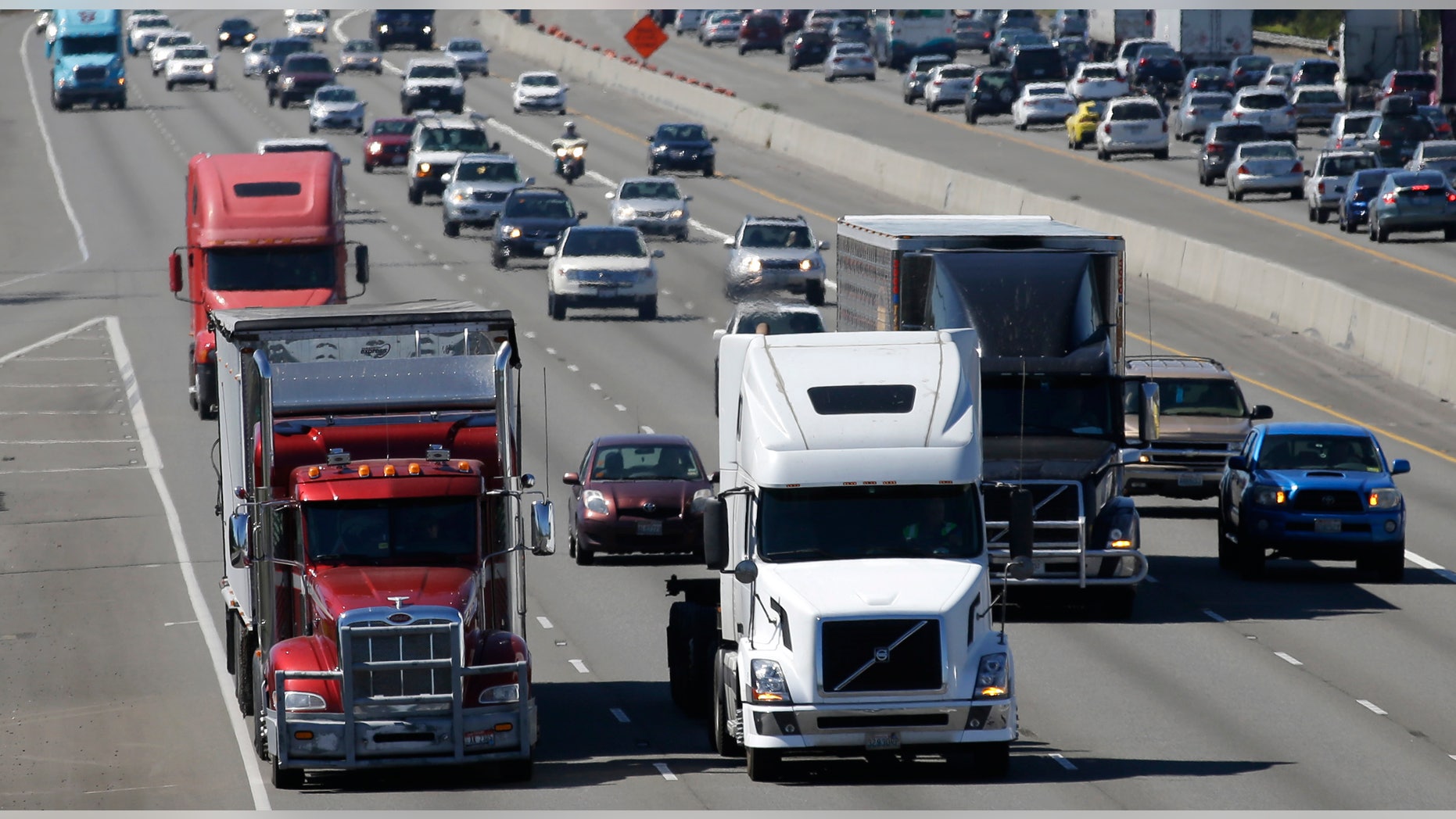 FILE - In this Wednesday, Aug. 24, 2016, file photo, truck and automobile traffic mix on Interstate 5, headed north through Fife, Wash., near the Port of Tacoma. (AP Photo/Ted S. Warren, File)