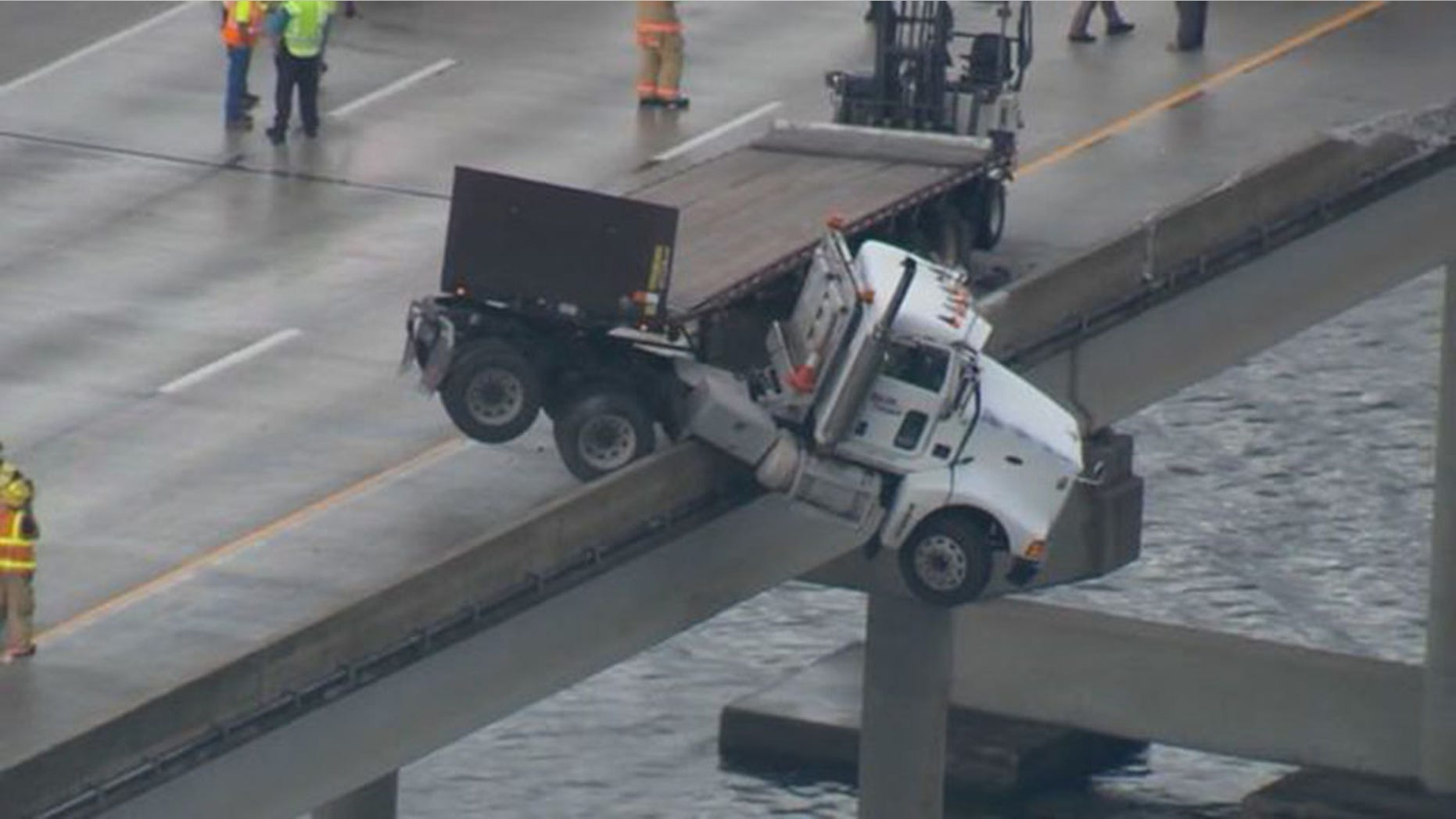 A semi-truck was suspended halfway over the side of a Florida overpass.