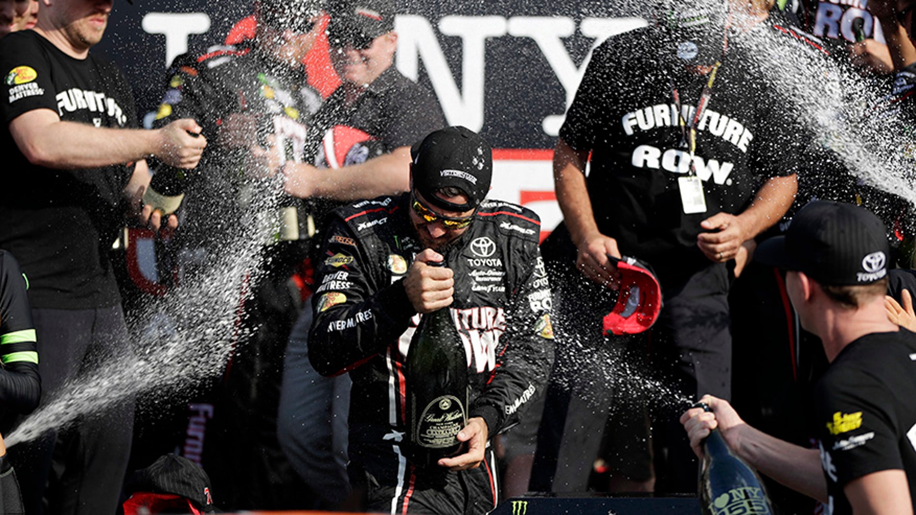 Martin Truex Jr., center, celebrates after winning the NASCAR Cup Series auto race, Sunday, Aug. 6, 2017, in Watkins Glen, N.Y. (AP Photo/Matt Slocum)
