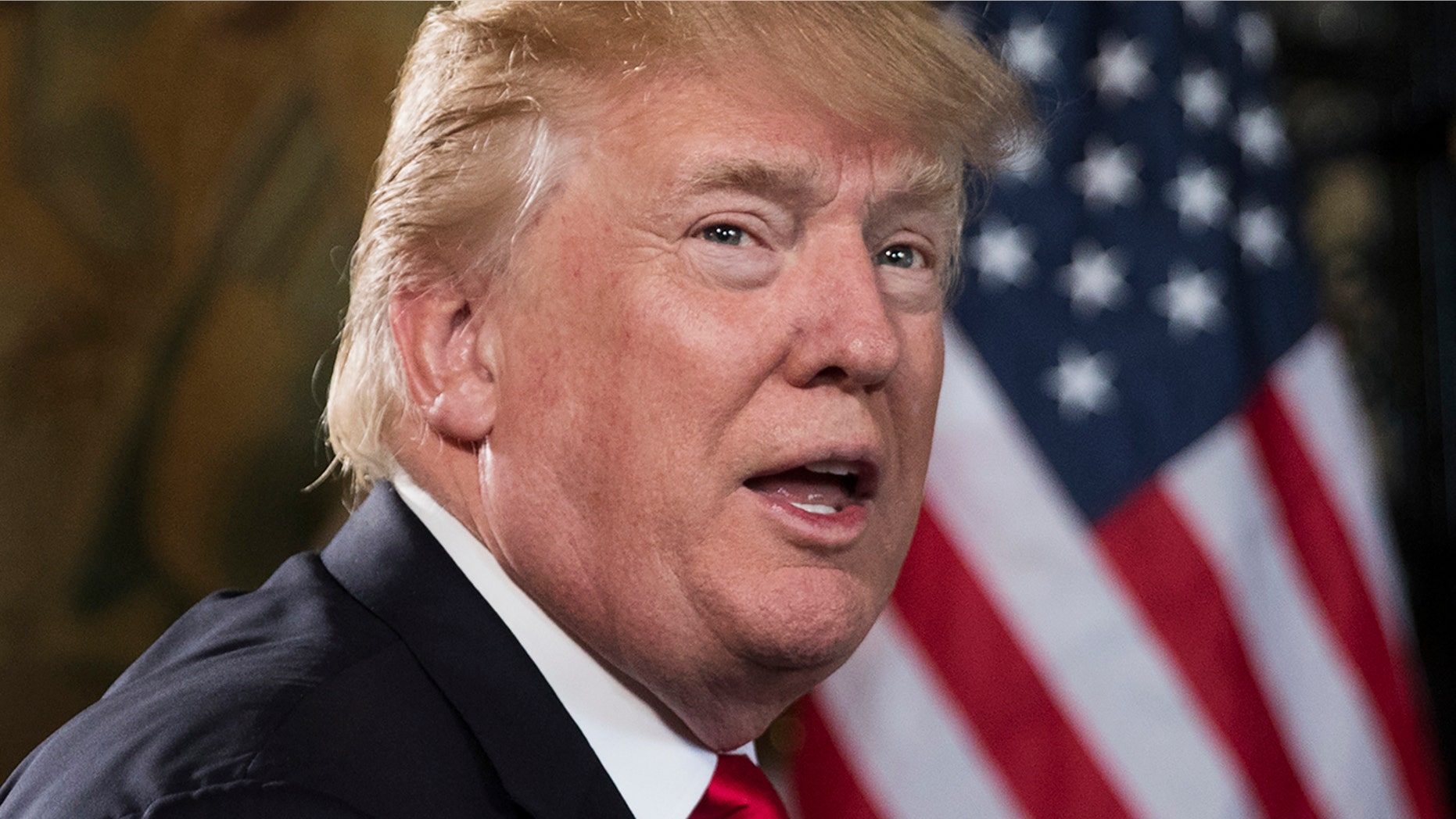 President Donald Trump turns to talk to the gathered media during a Christmas Eve video teleconference with members of the mIlitary at his Mar-a-Lago estate in Palm Beach, Fla., Sunday, Dec. 24, 2017. (AP Photo/Carolyn Kaster)